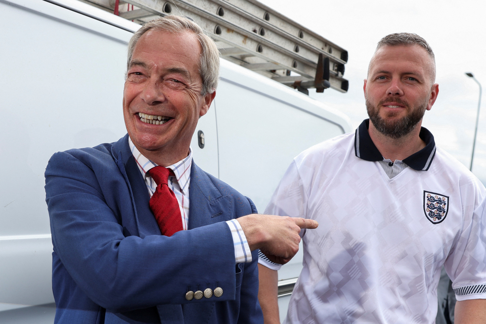 Reform UK leader Nigel Farage reacts next to Reform UK by-election candidate Rob Kenyon as they arrive during the Makerfield by-election, triggered by the resignation of Labour MP John Simons, at St. Aidan's Parish Centre, Wigan, Britain on June 18, 2026. [Temilade Adelaja/Reuters]