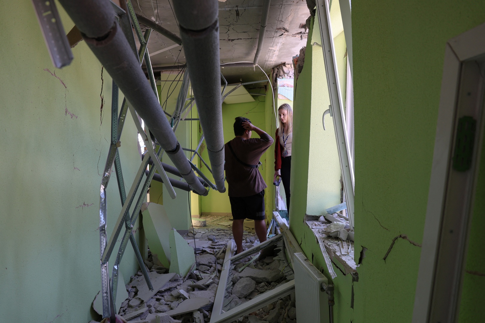 People stand in a hallway of a damaged residential building following a Russian strike in Odesa on July 15, 2026, amid the Russian invasion of Ukraine. [Oleksandr Gimanov/AFP]
