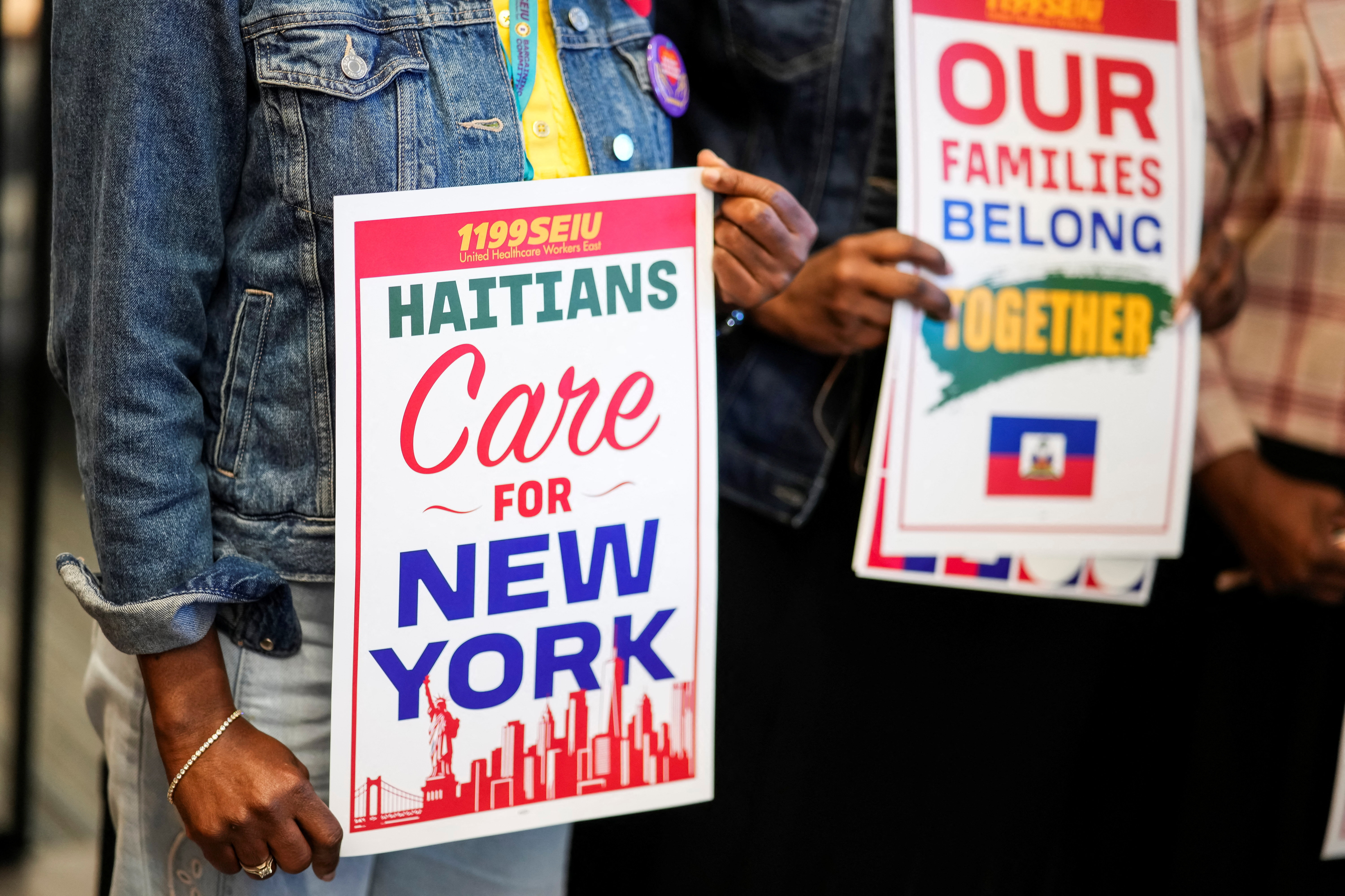 People hold placards during a rally with immigration advocates, on the day of the U.S. Supreme Court ruling allowing the Trump administration to strip Temporary Protected Status (TPS) protections from hundreds of thousands of Haitian and Syrian migrants, in New York City, U.S., June 25, 2026. REUTERS/Eduardo Munoz