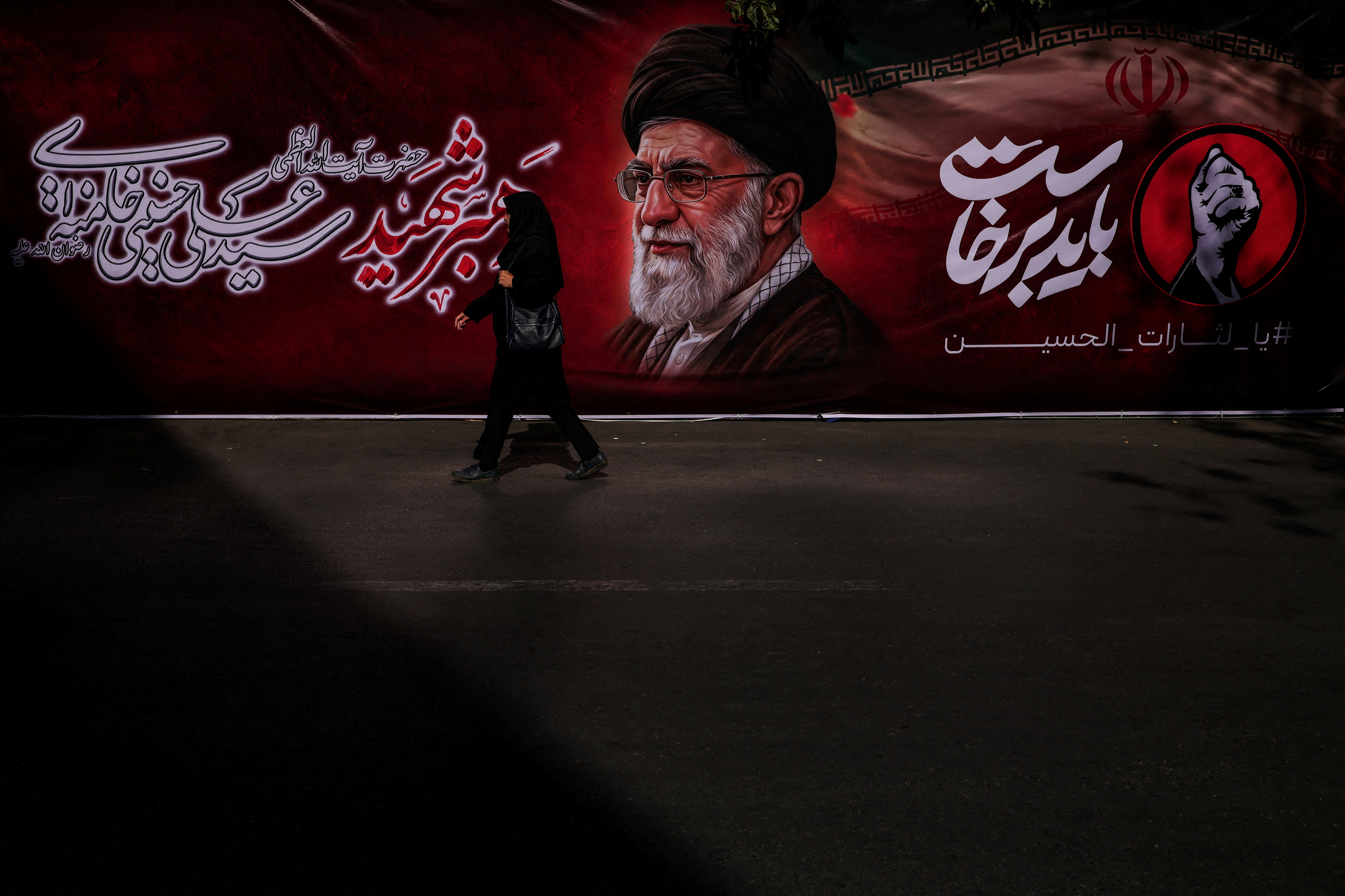 A woman walks past a banner depicting Iran's late Supreme Leader Ayatollah Ali Khamenei, who was killed on February 28 in Israeli and U.S. airstrikes, near the Imam Khomeini Grand Mosalla, in Tehran, Iran July 3, 2026. REUTERS/Alkis Konstantinidis Foreign media in Iran operate under guidelines set by the Ministry of Culture and Islamic Guidance, which regulates press activity and permissions ISRAEL OUT. NO COMMERCIAL OR EDITORIAL SALES IN ISRAEL. NO ACCESS FOR ISRAELI MEDIA. NO USE BBC PERSIAN. NO USE VOA PERSIAN. NO USE MANOTO. NO USE IRAN INTERNATIONAL. NO USE RADIO FARDA. DIGITAL: NO USE BBC PERSIAN. NO USE VOA PERSIAN. NO USE MANOTO. NO USE IRAN INTERNATIONAL. NO USE RADIO FARDA. TPX IMAGES OF THE DAY