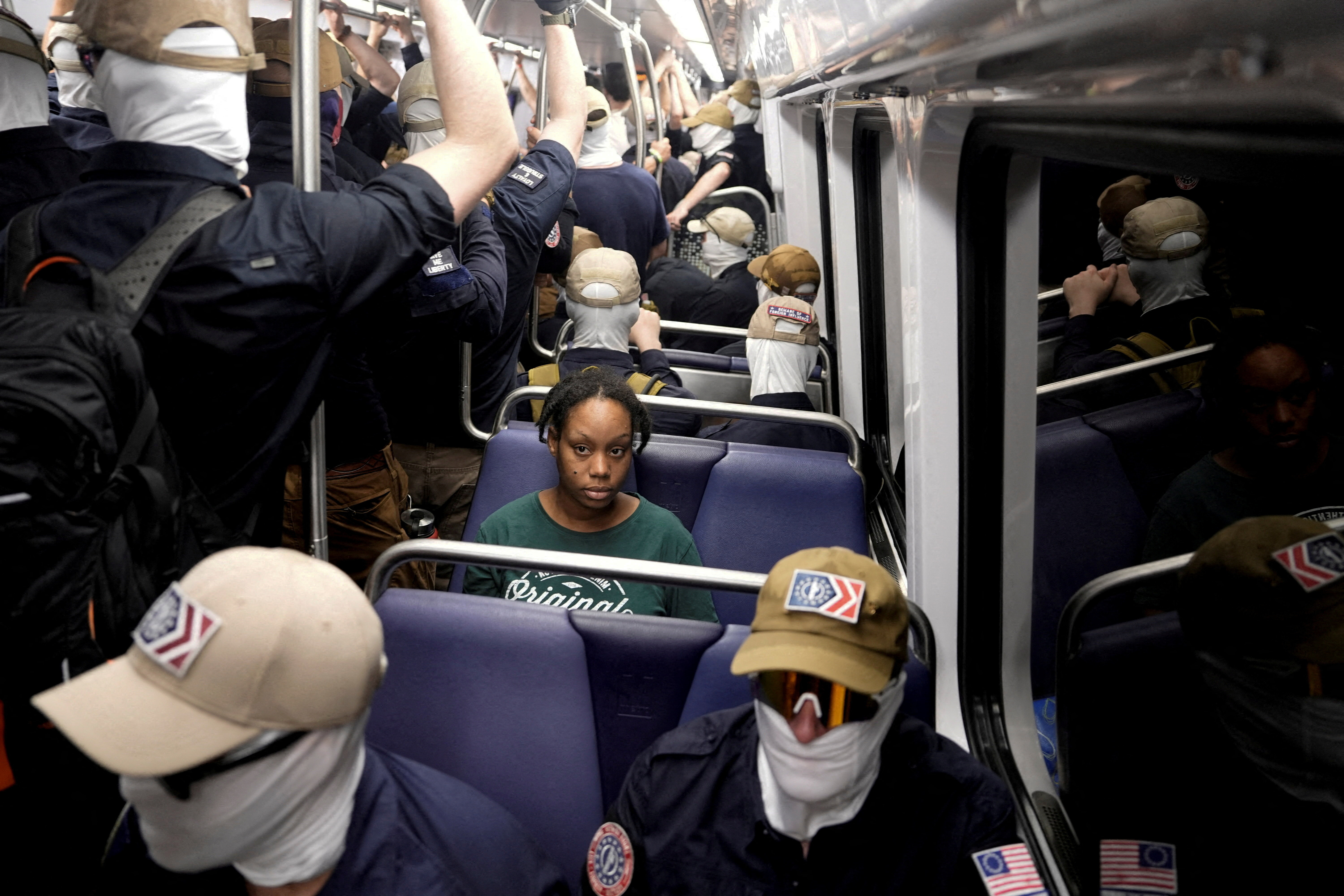 A commuter sits as members of the group Patriot Front ride the metro on the 250th anniversary of U.S. independence on the Fourth of July in Washington, D.C., U.S., July 4, 2026. REUTERS/Cheney Orr TPX IMAGES OF THE DAY