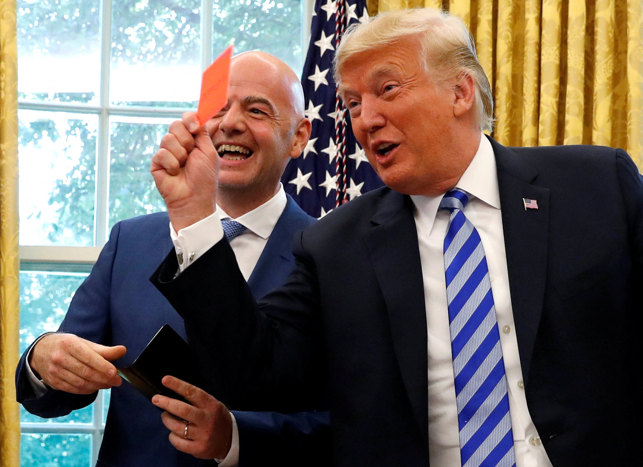 FILE PHOTO: U.S. President Donald Trump holds up a red card as he meets with FIFA President Gianni Infantino in the Oval Office of the White House in Washington, U.S., August 28, 2018. REUTERS/Leah Millis/File Photo