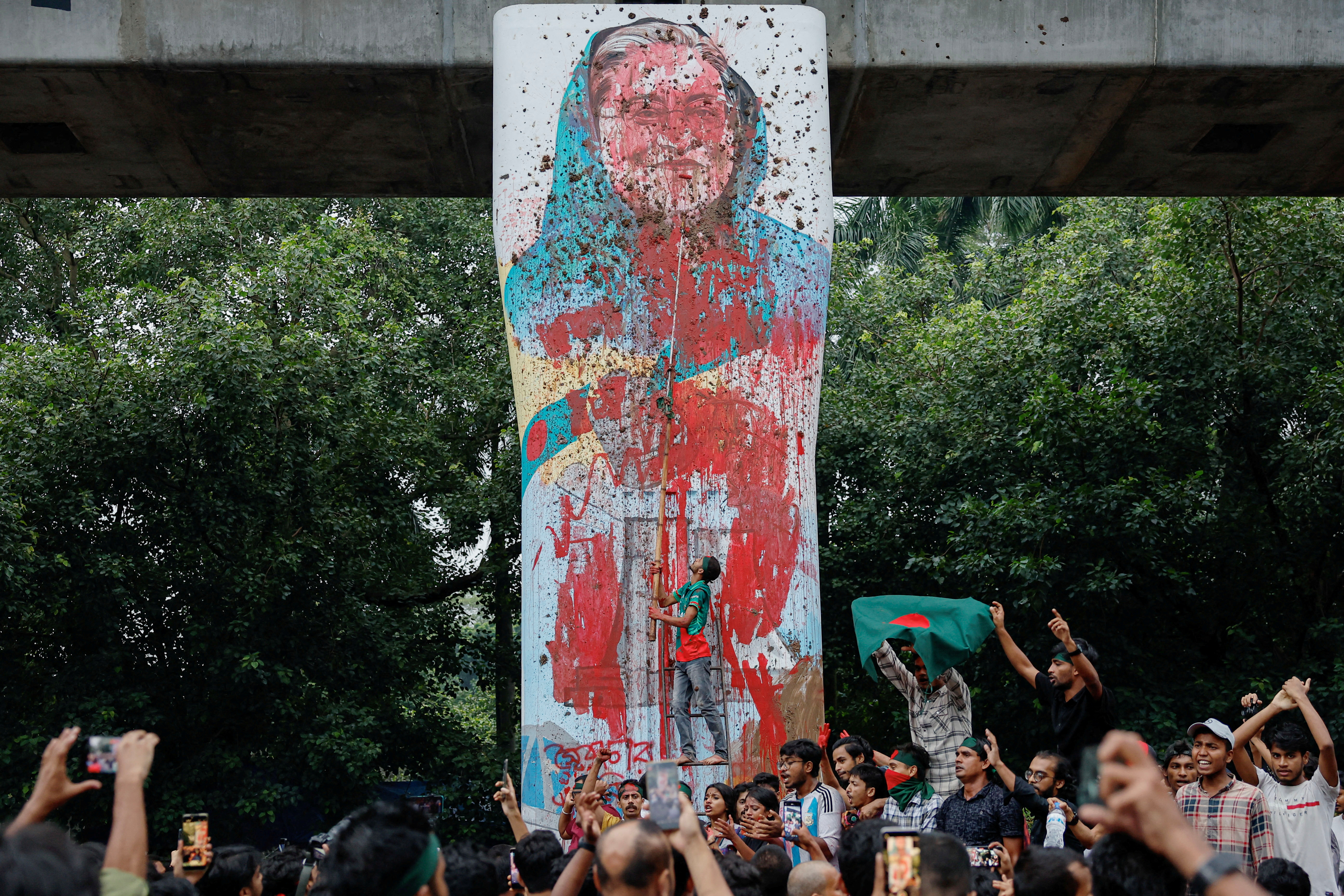 FILE PHOTO: Protesters shout slogans as they vandalise a mural of Bangladeshi Prime Minister Sheikh Hasina with paint and mud, demanding her resignation at Teacher Student Center (TSC) area of University of Dhaka in Dhaka, Bangladesh, August 3, 2024. REUTERS/Mohammad Ponir Hossain/File Photo