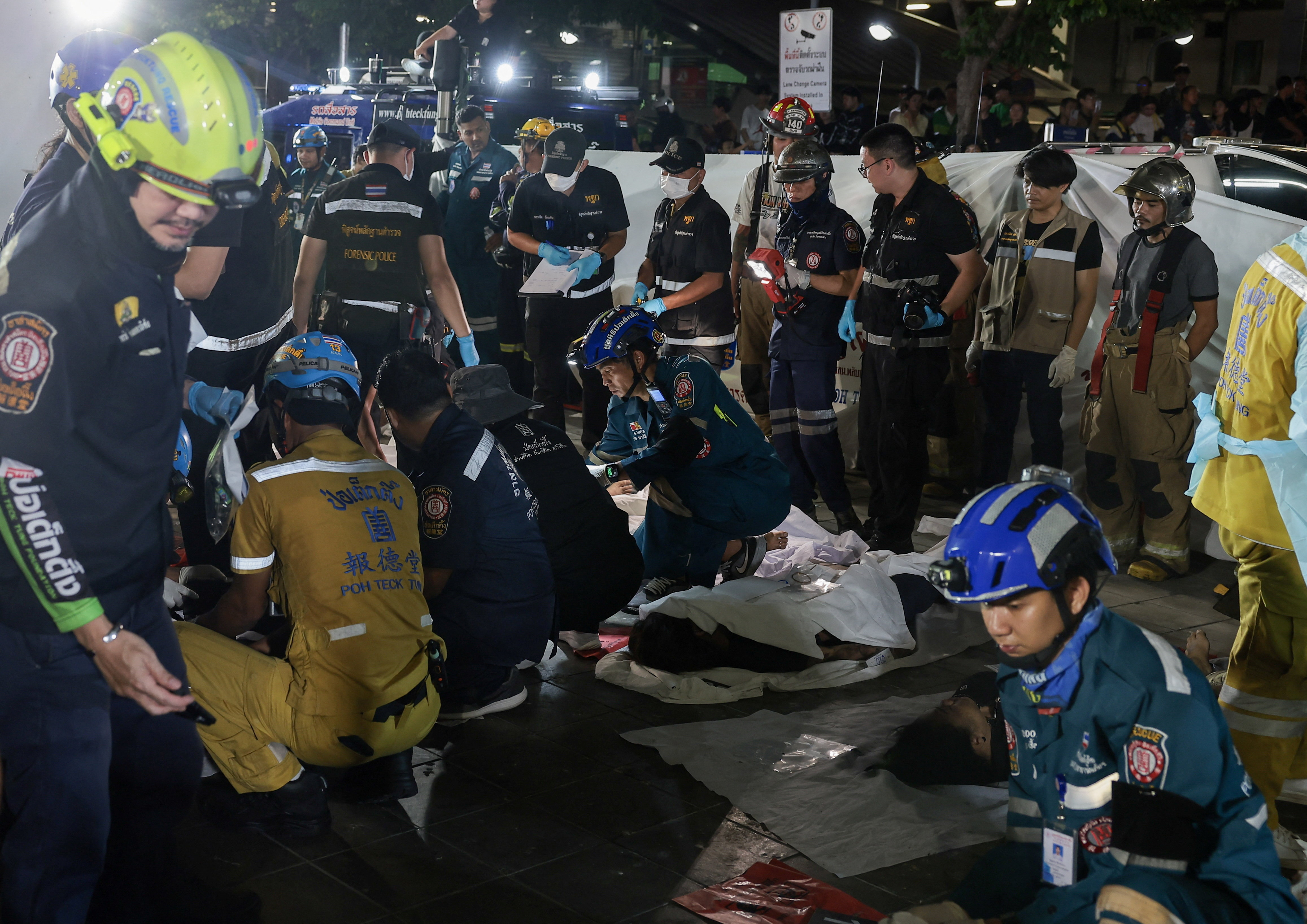 Members of emergency personnel work next to casualties at the site of a deadly fire at a pub in Bangkok, Thailand