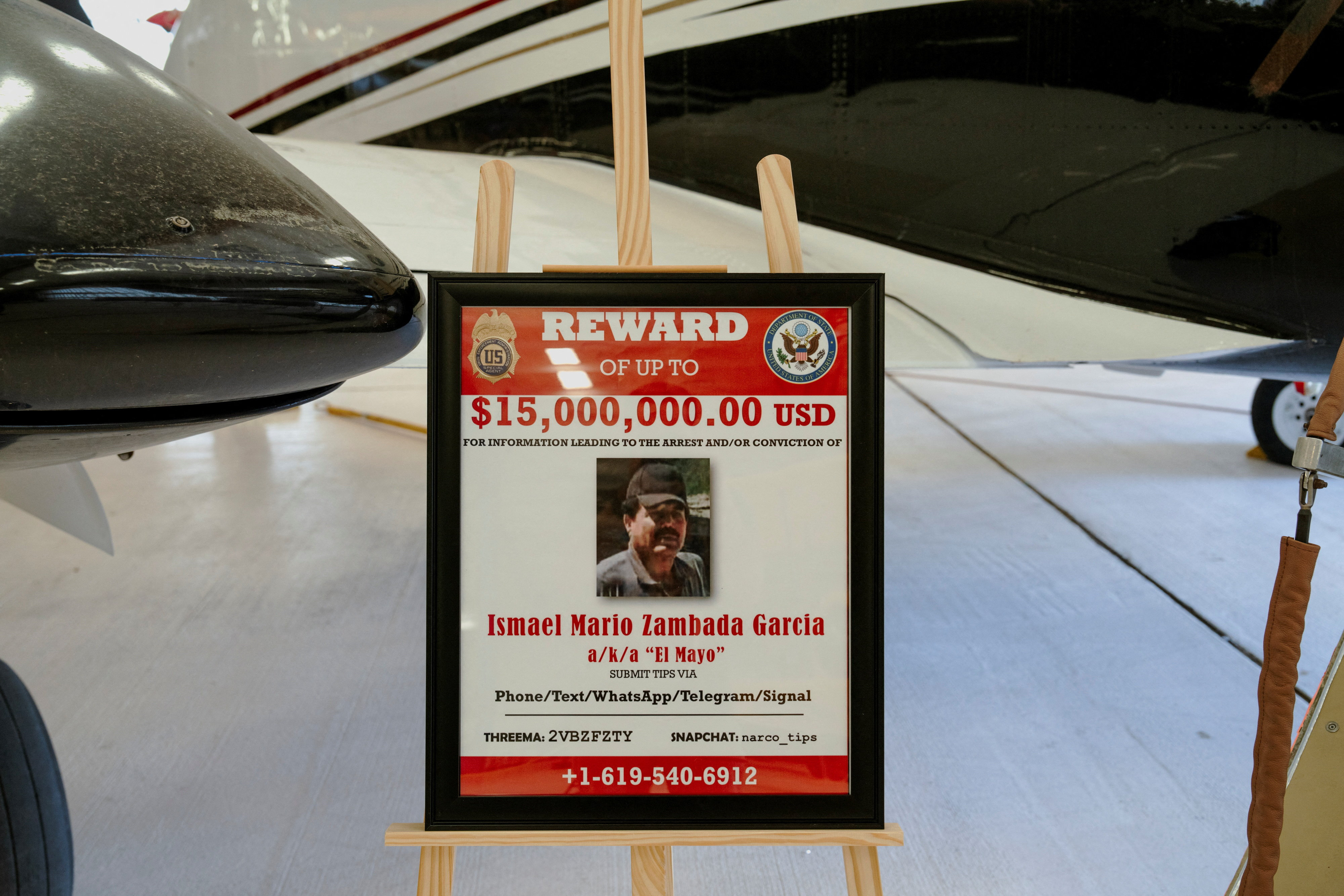 A reward sign for former Sinaloa Cartel leader Ismael "El Mayo" Zambada is posted next to a Beechcraft King Air aircraft, used in July 2024 to transport to the U.S. Zambada and Joaquin Guzman Lopez, the son of notorious narco leader "El Chapo" Guzman, at the War Eagles Air Museum, where the plane is on loan from the FBI, in Santa Teresa, New Mexico, U.S. July 9, 2026. REUTERS/Paul Ratje