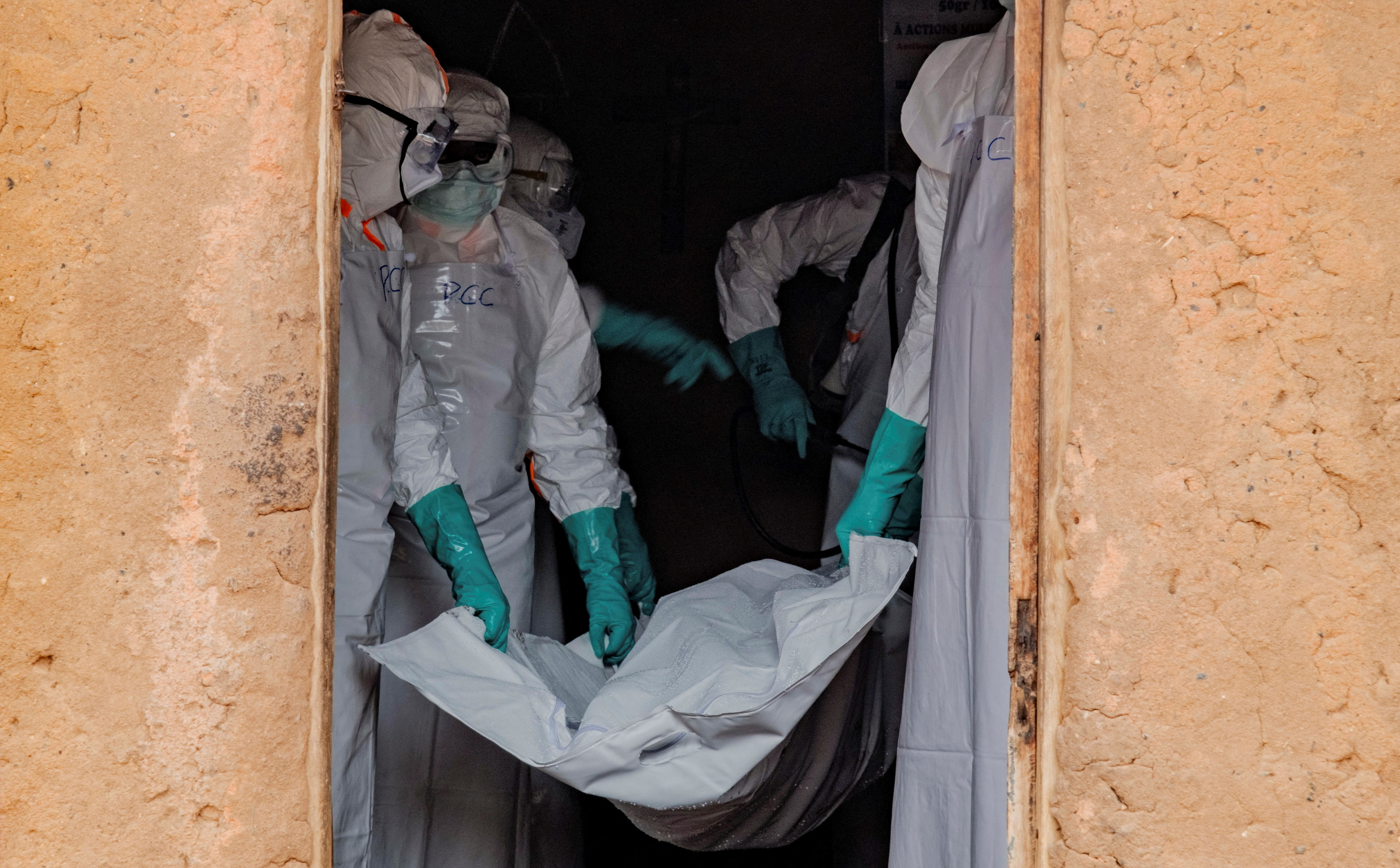 Members of the Civil Protection, a local, community-based team that helps lower resistance and ensures burials happen safely and quickly, while wearing personal protective equipment (PPE), carry a body bag with the remains of an unidentified man who, according to his family, died of Ebola, after picking up his body at his house, as aid agencies intensify efforts to contain an Ebola outbreak involving the Bundibugyo strain, in Bunia, Ituri province, Democratic Republic of Congo, July 10, 2026. REUTERS/Gradel Muyisa Mumbere