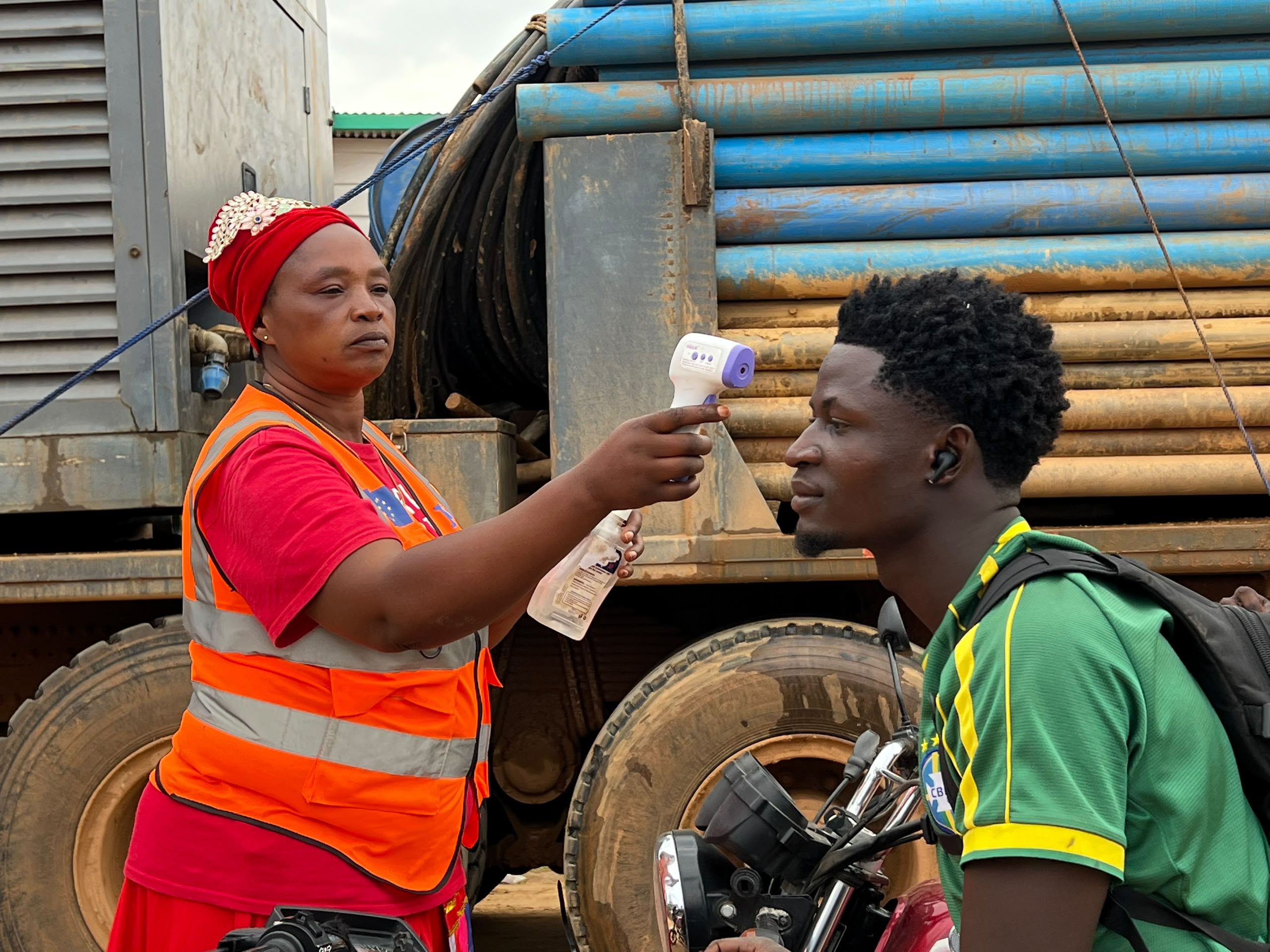 A health worker takes a man's temperature.