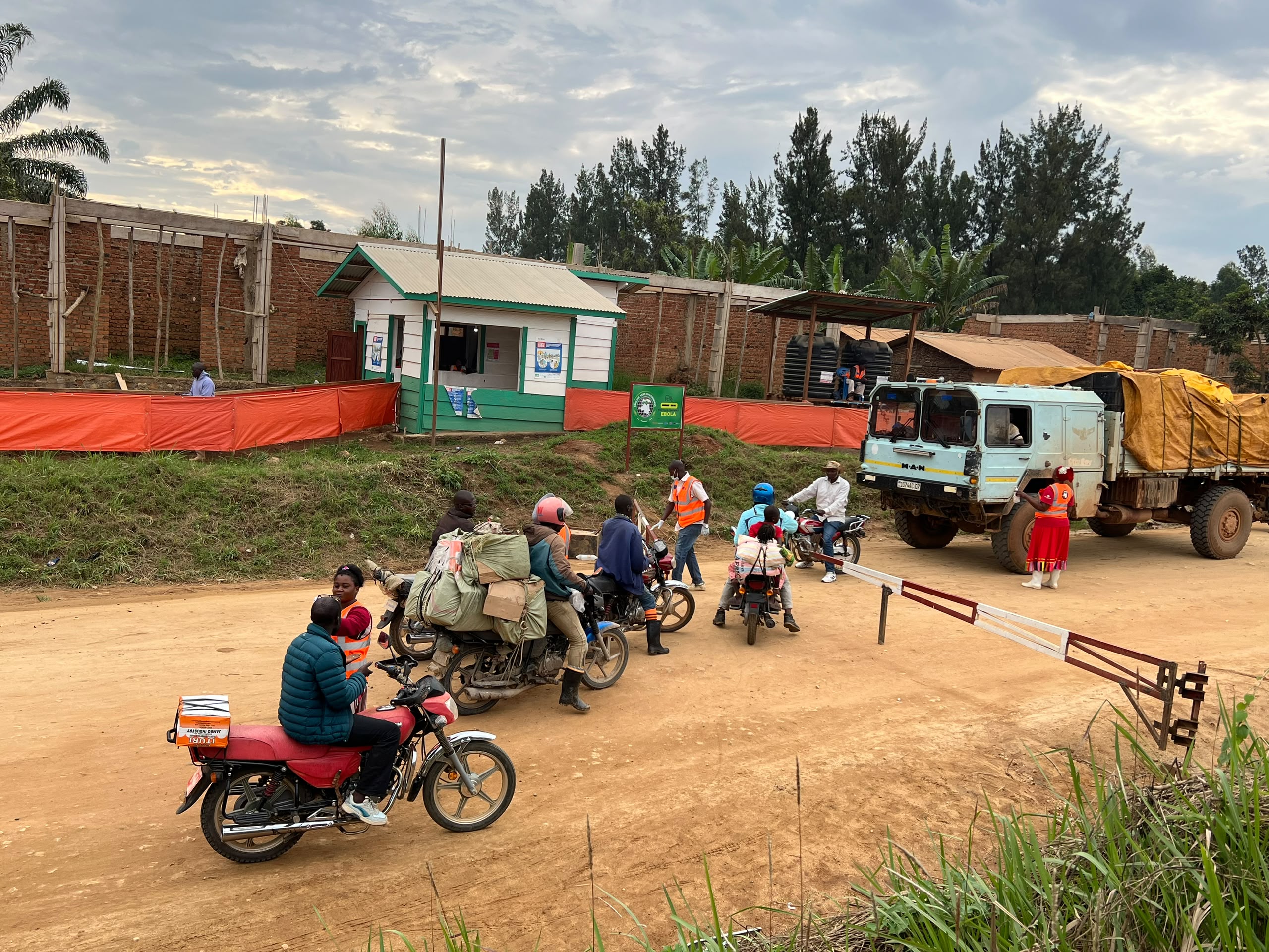 Motorbike riders have their temperatures checked by a Virunga National Park health agent at an Ebola screening checkpoint in northern Bunia, Democratic Republic of the Congo. [Prosper Heri Ngorora/Al Jazeera]