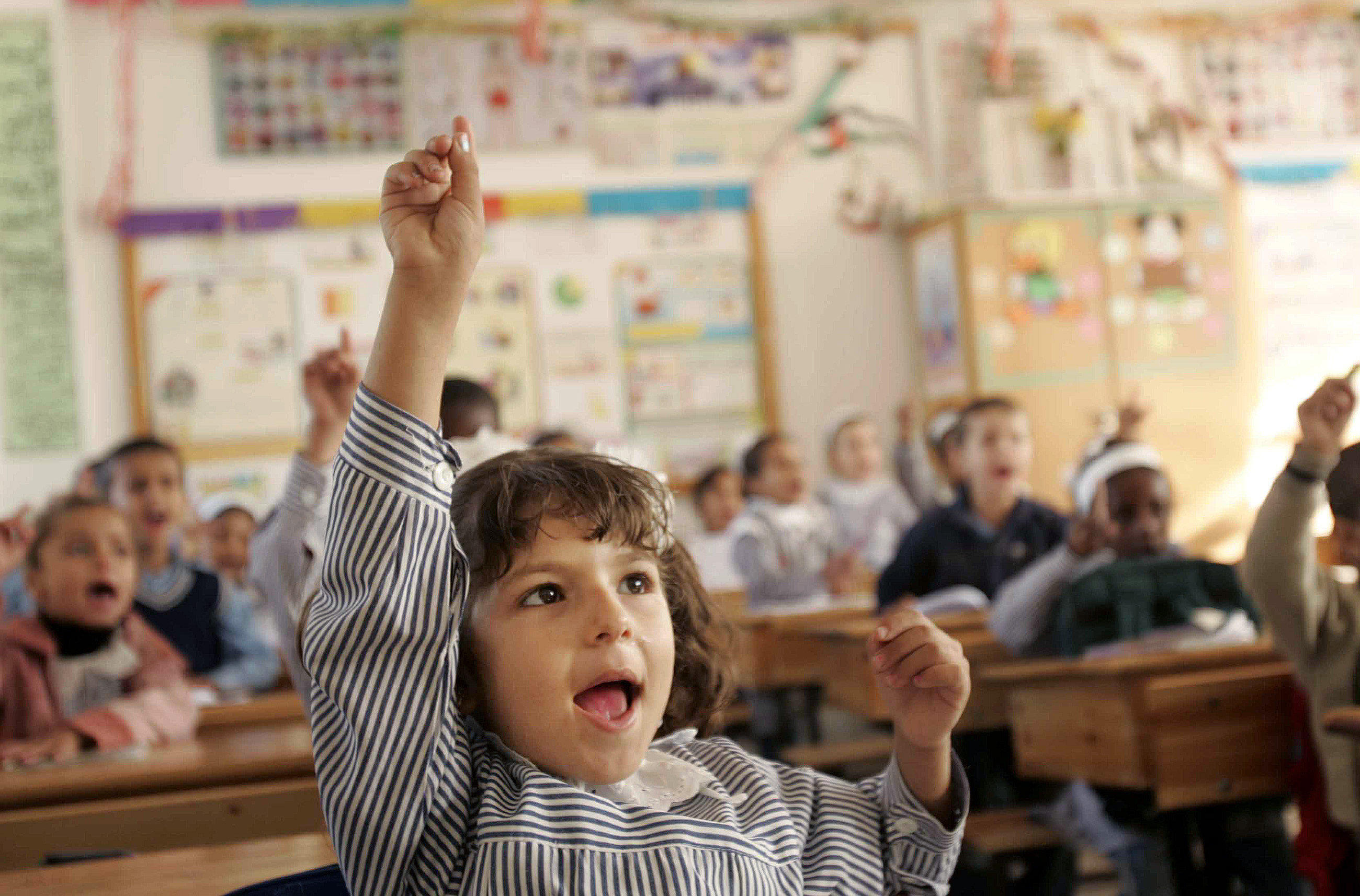 Palestinian students sit inside their new school opened by the United Nations Relief and Works Agency for Refugees (UNRWA) in southern Gaza November 17, 2007. REUTERS/Ibraheem Abu Mustafa (GAZA)