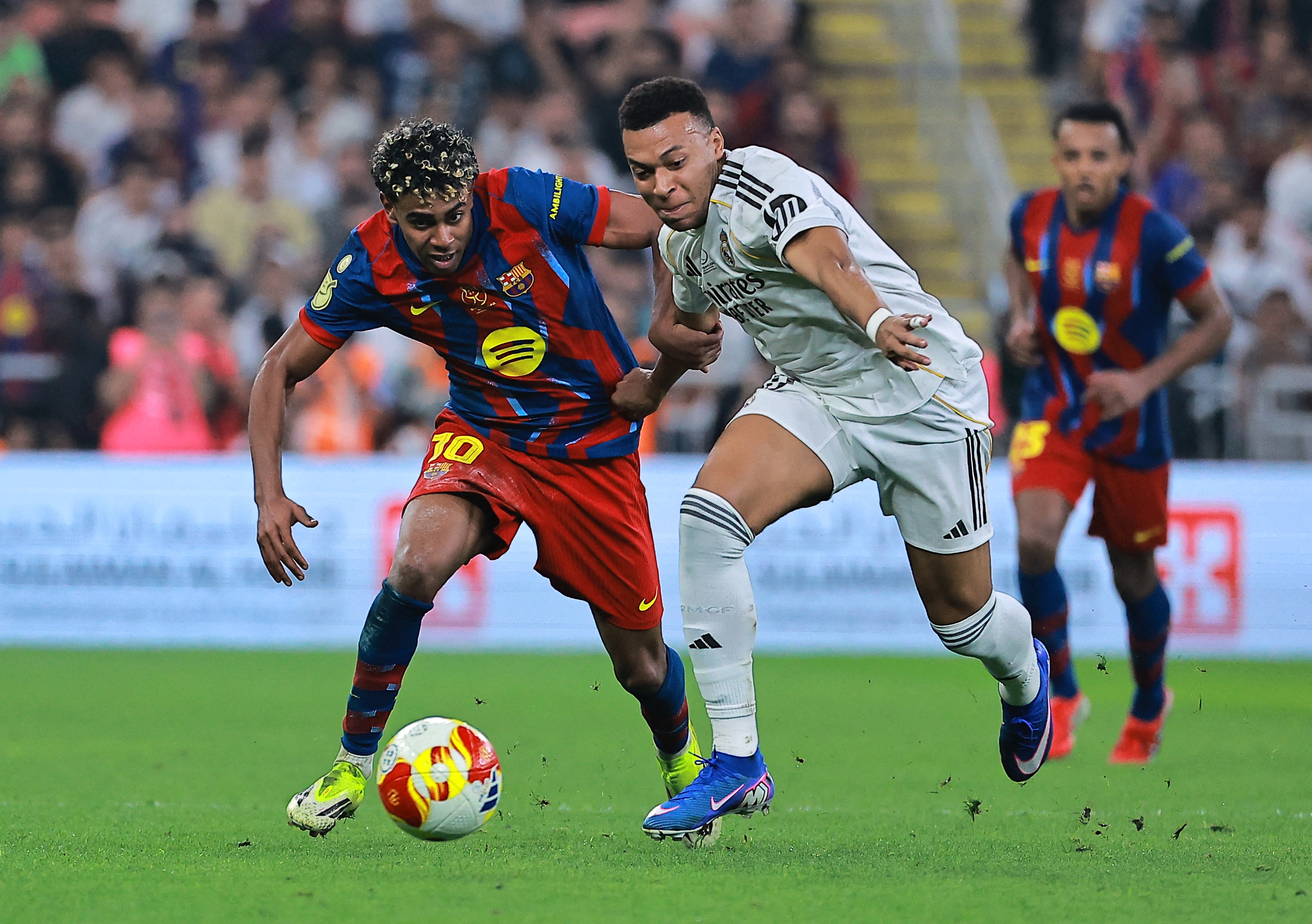 Real Madrid's Kylian Mbappe in action with FC Barcelona's Lamine Yamal