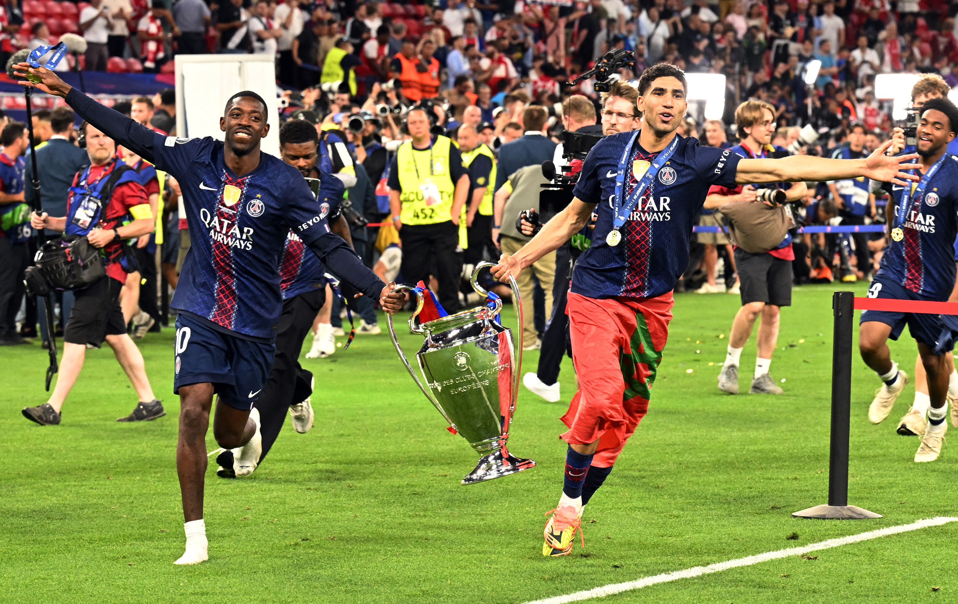 Paris St Germain's Ousmane Dembele and Achraf Hakimi celebrate with the trophy after winning the UEFA Champions League