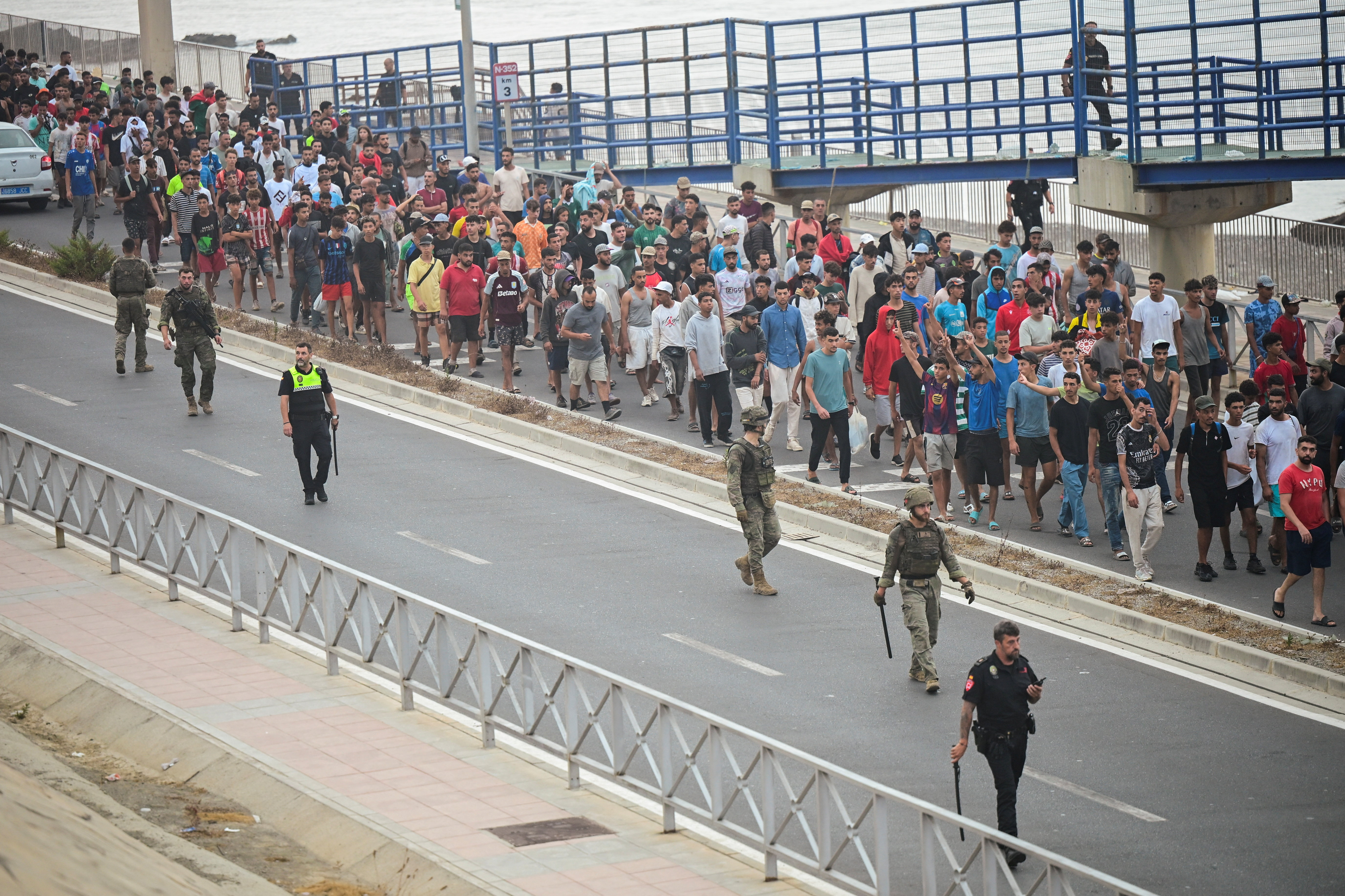 Spanish police officers and soldiers escort a big group of migrants to the border to take them out of Spain, after mass crossings of migrants on foot and by sea from Morocco into Spanish territory, in Ceuta, Spain, August 1, 2026. REUTERS/Fabian Bimmer