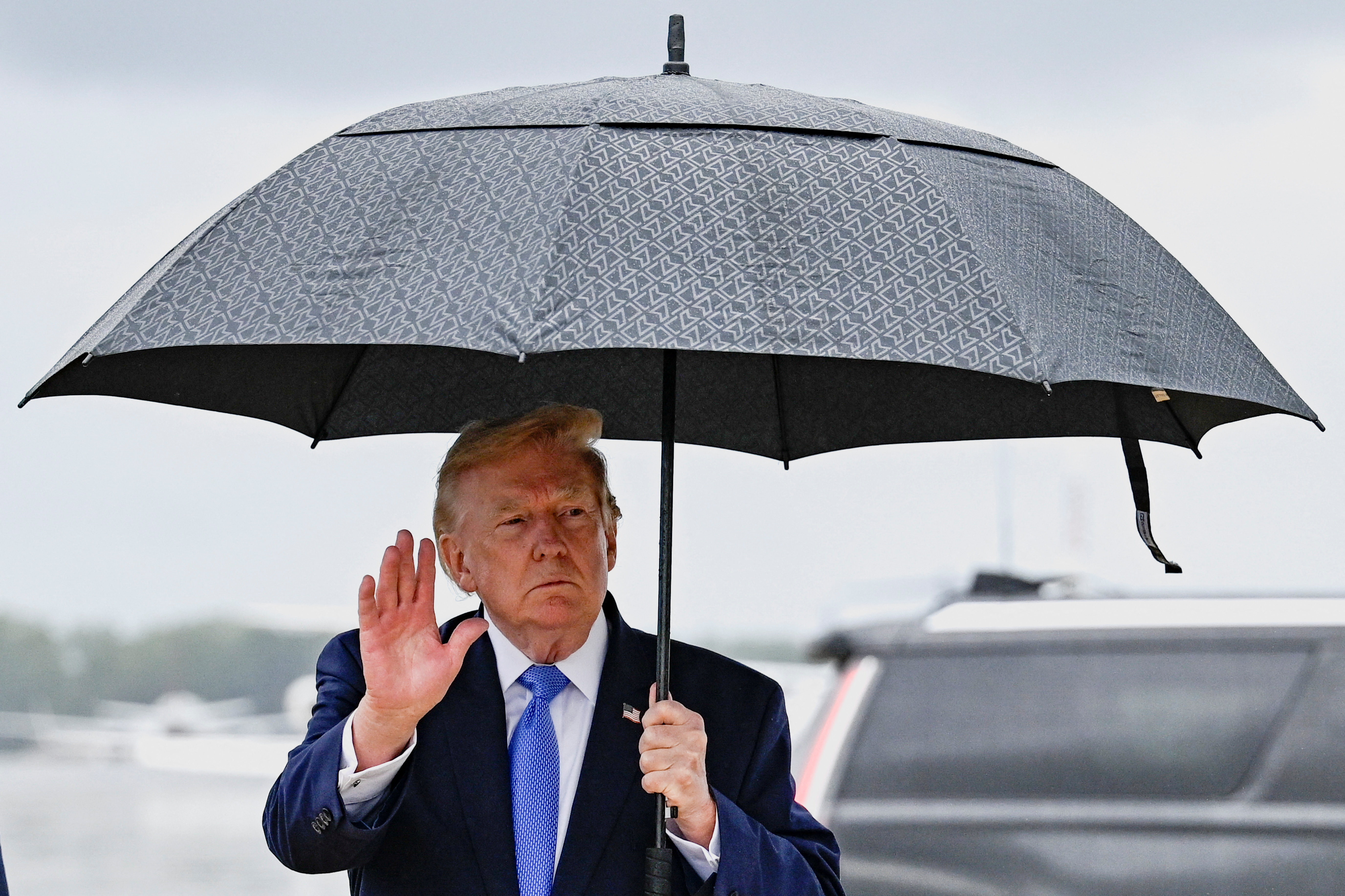 A man under an umbrella waves