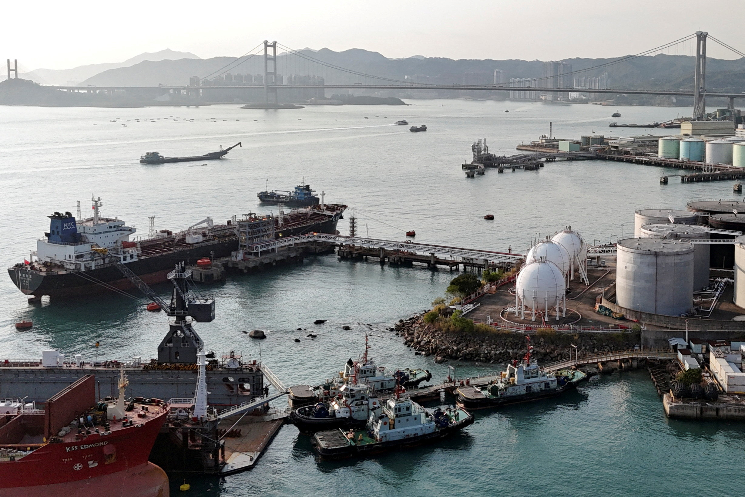 A drone view shows a Chinese-flagged oil tanker moored at an oil terminal at Tsing Yi port, with Tsing Ma bridge in the background, in Hong Kong, China on March 19, 2026