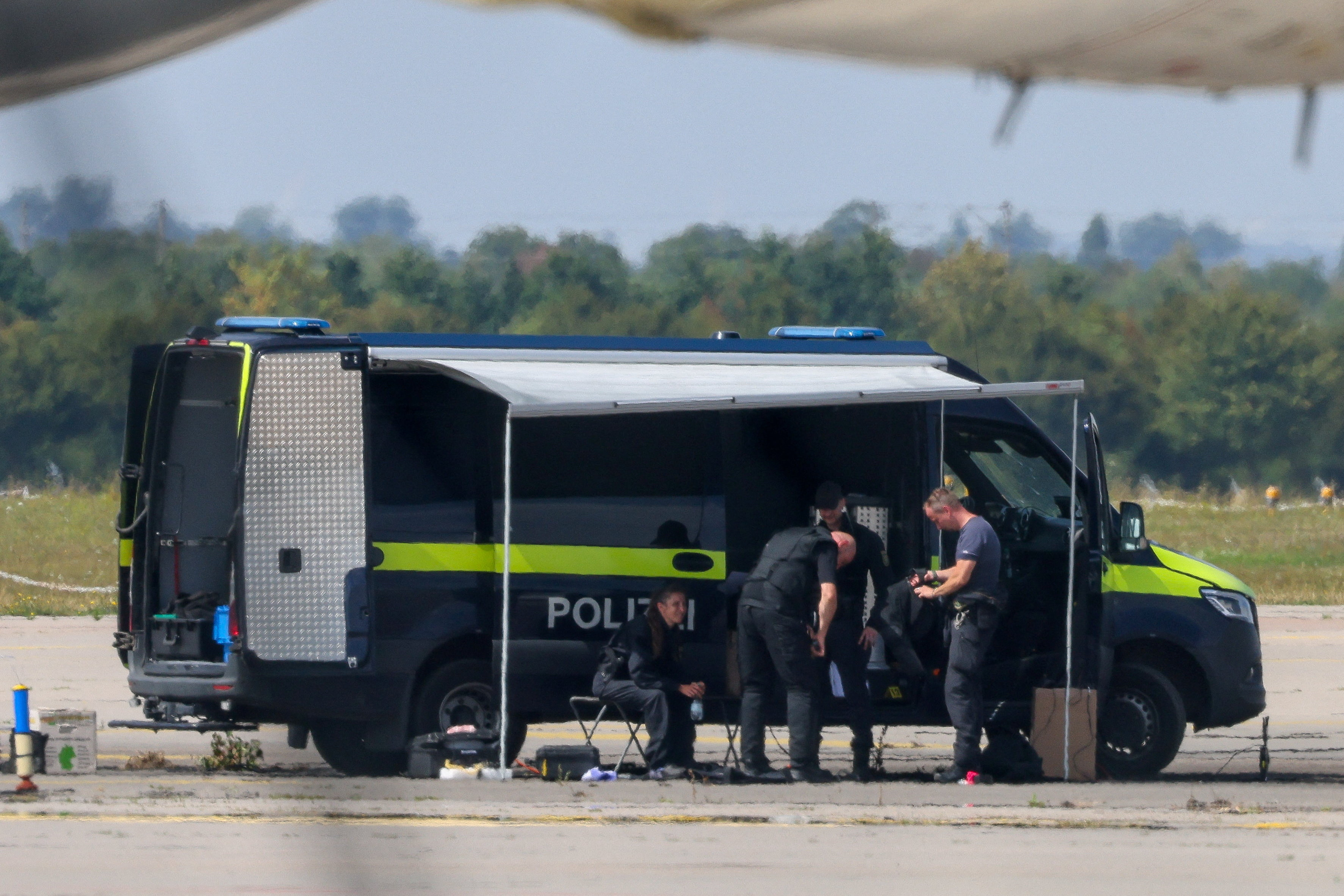 Police officers work in the vicinity of an Antonov cargo plane, near which a drone was found, at Leipzig/Halle Airport in Schkeuditz, Germany, August 5, 2026, after the police said explosives experts examined a drone near a runway, and after a DHL cargo aircraft hit an unknown object as it was climbing away from the airport overnight, prompting an unscheduled landing in Hanover, according to a source familiar with the incident. REUTERS/Axel Schmidt