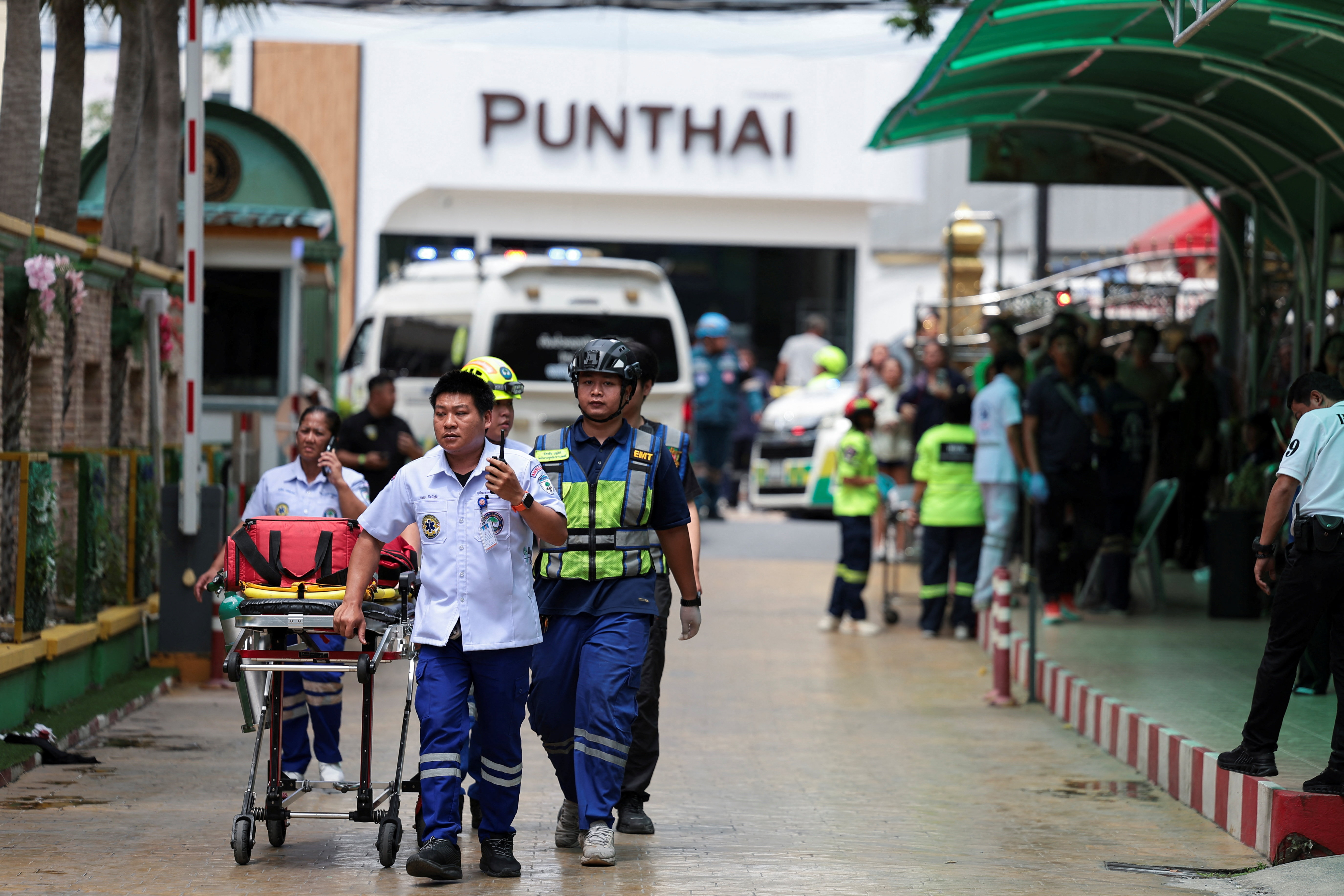 Emergency services pushing a stretcher outside a school.