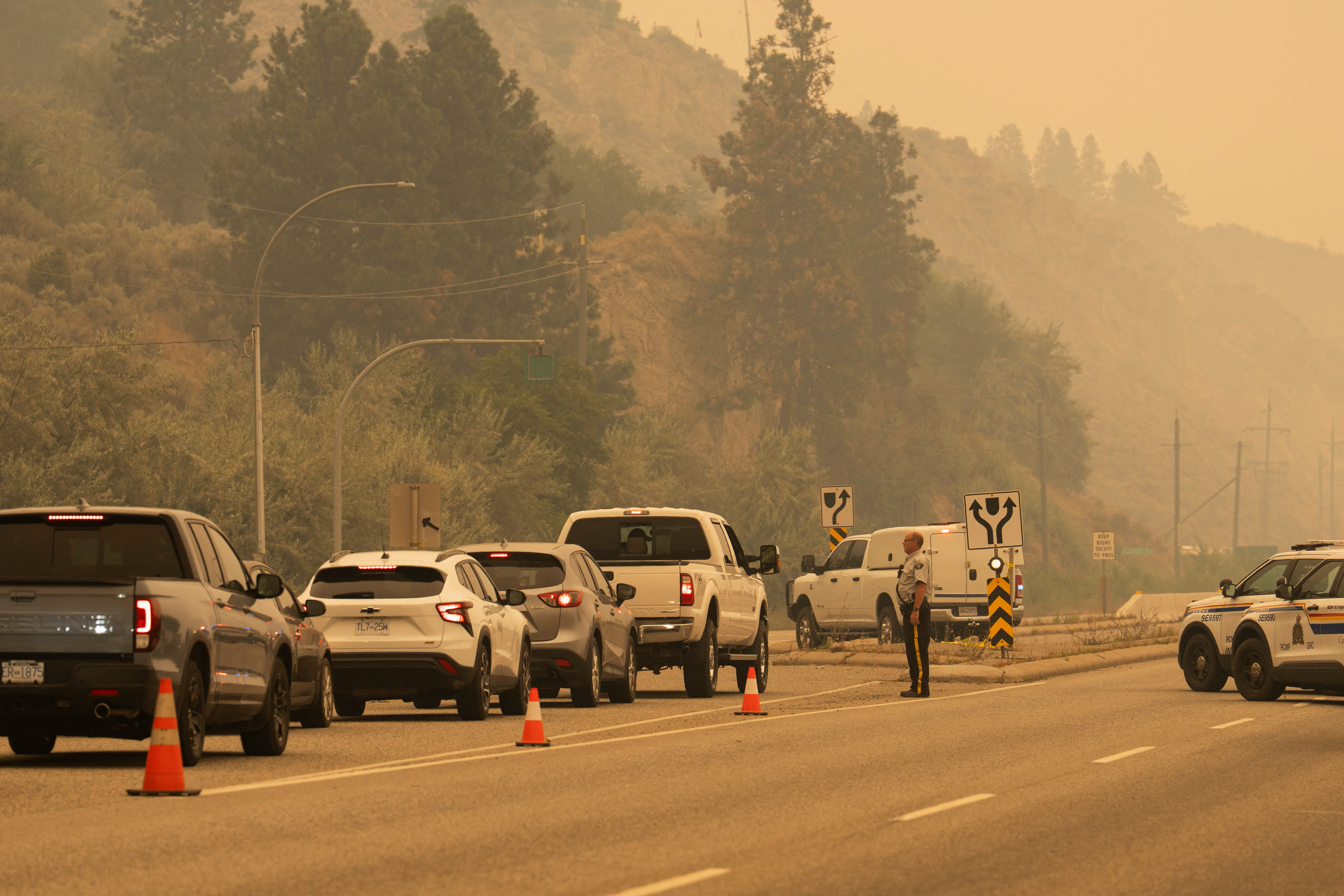 The Royal Canadian Mounted Police block Highway 97 Northbound to direct people away from the Bald Range wildfire in Penticton, British Columbia, Canada on August 8, 2026 [Paige Taylor White/Reuters]