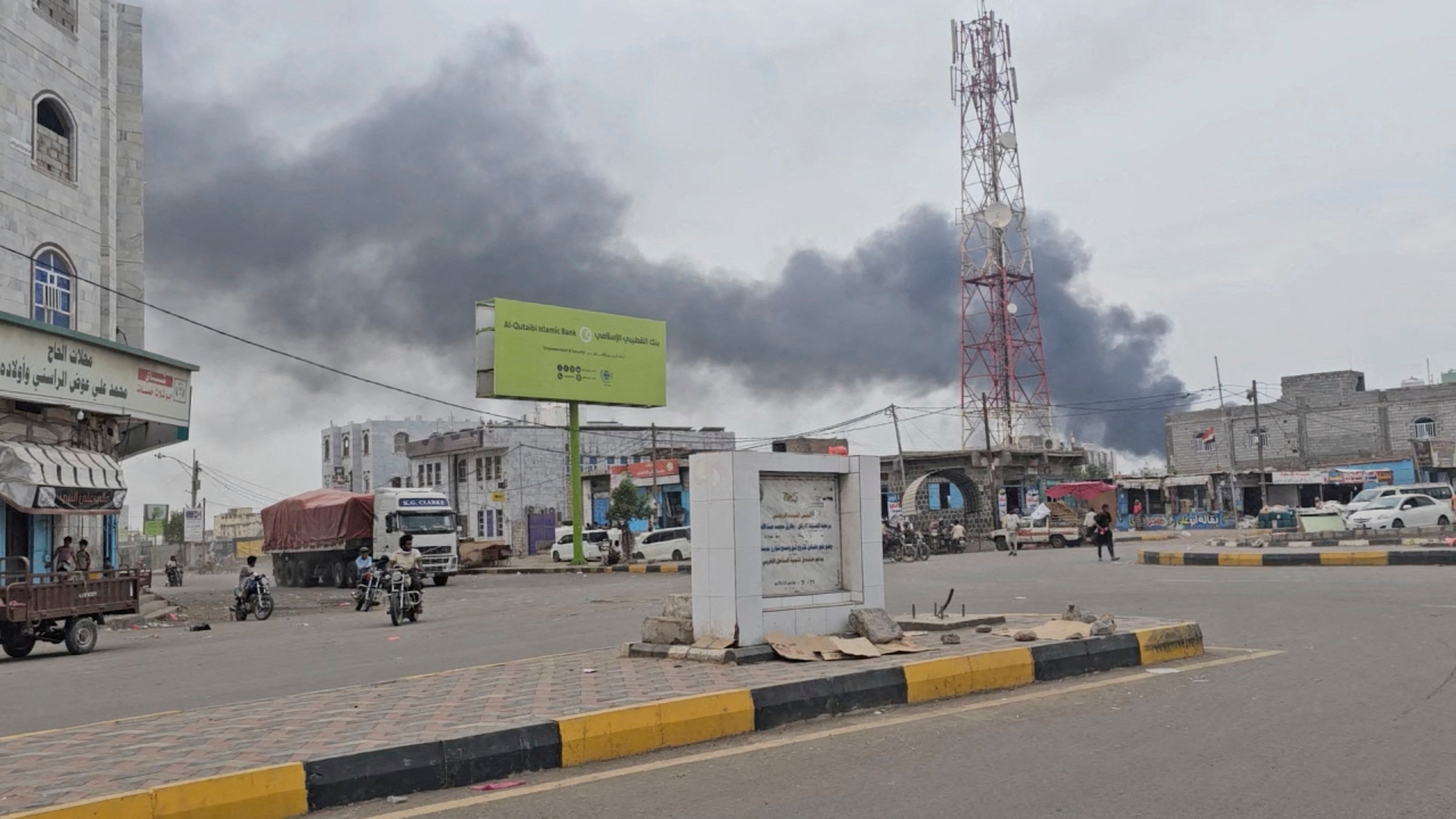 Smoke rises behind buildings.