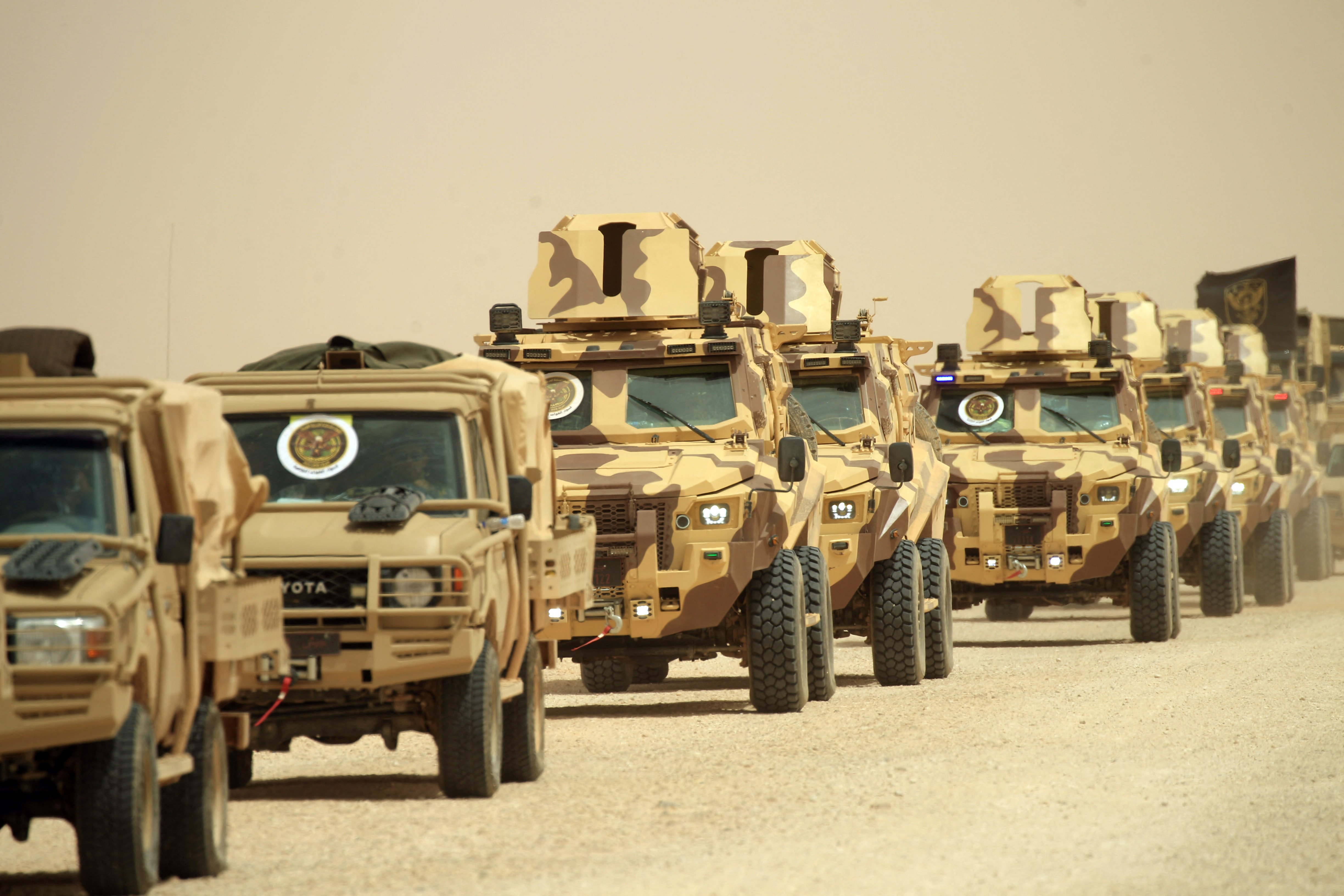 Libyan army vehicles drive in a file.