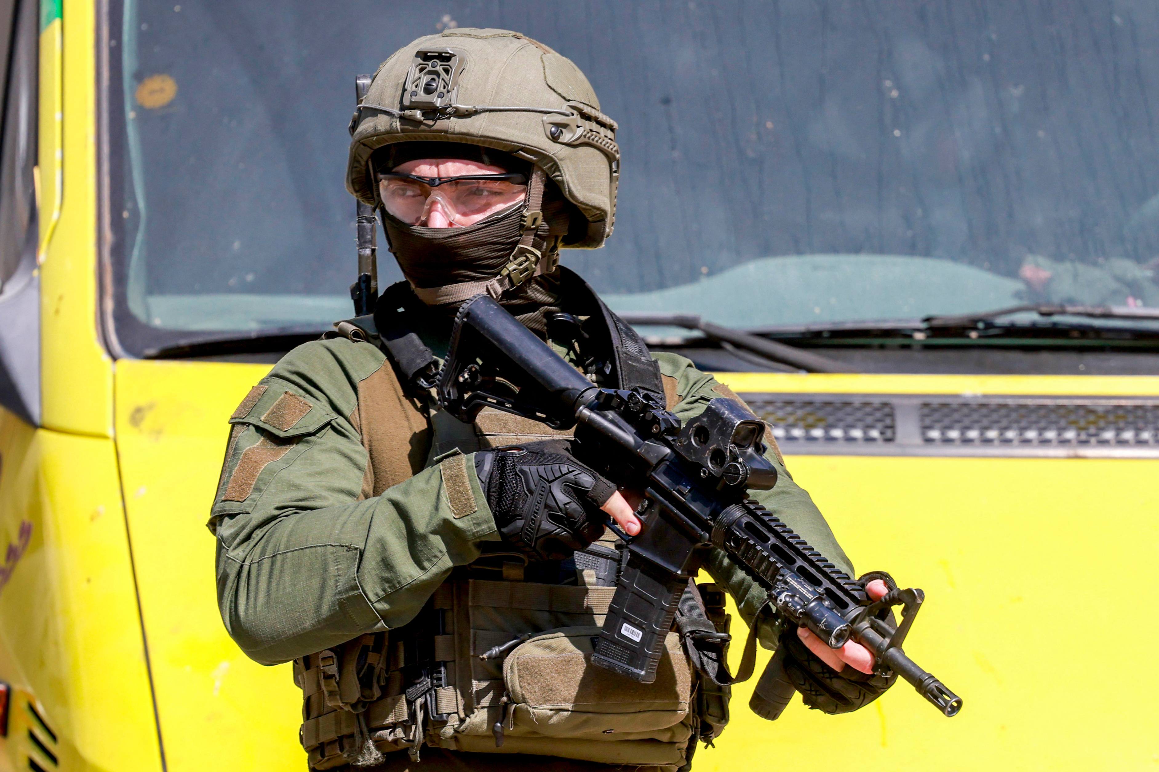 An Israeli army soldier stands with a rifle before a Palestinian school bus during a military operation in Nablus in the occupied West Bank on August 2, 2026. (Photo by Jaafar ASHTIYEH / AFP)