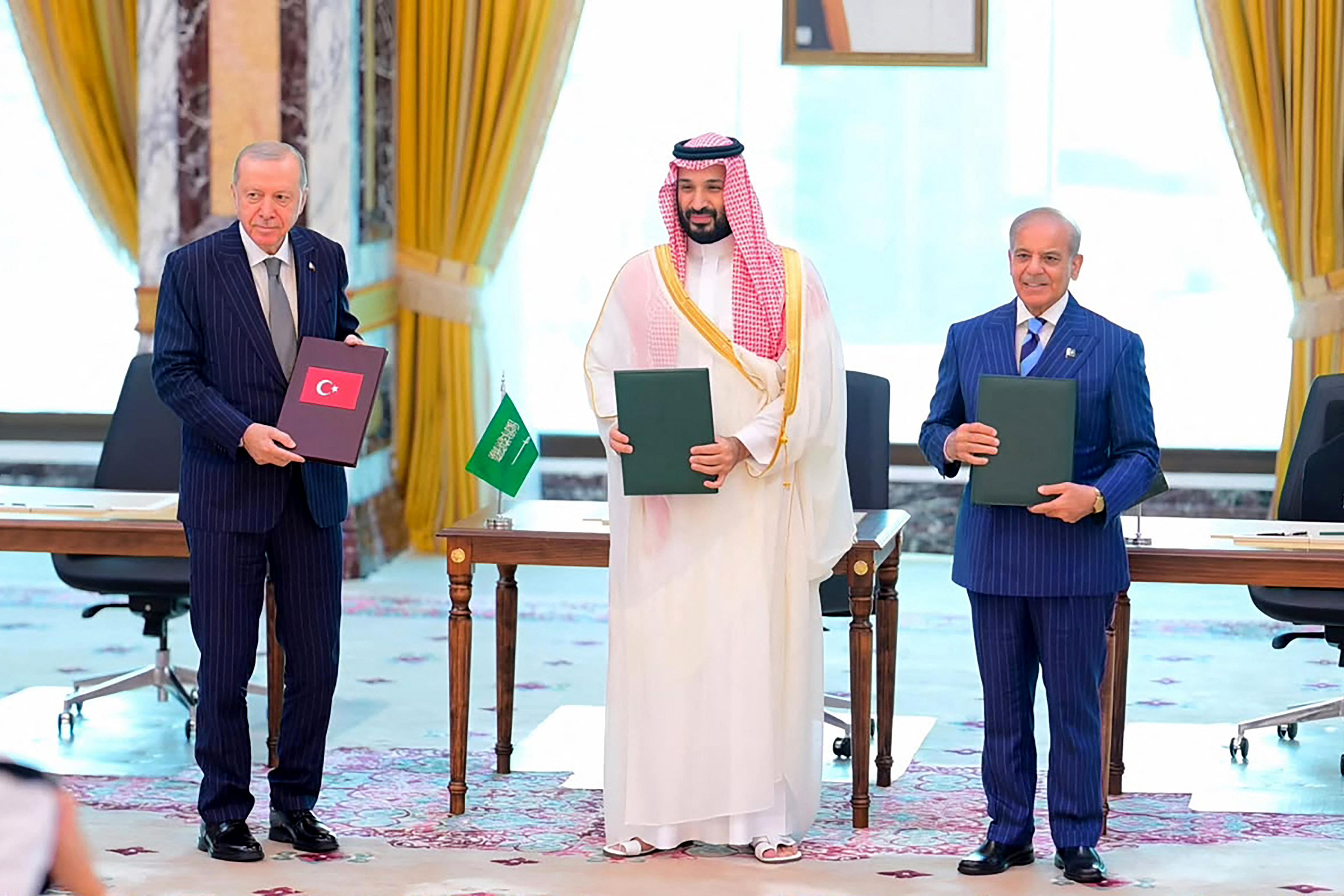 This handout photograph taken and released by Pakistan's Prime Minister's Office on August 7, 2026 shows Saudi Crown Prince Mohammed bin Salman (C), Turkish President Recep Tayyip Erdogan (L) and Pakistani Prime Minister Shehbaz Sharif posing after signing the Mecca Joint Defence Agreement in Mecca, Saudi Arabia. Saudi Arabia, Turkey and Pakistan signed a joint defence agreement on August 7 amid violence in the region from Houthi attacks and the US-Iran war. (Photo by Handout / Pakistan Prime Minister's Office / AFP) / RESTRICTED TO EDITORIAL USE - MANDATORY CREDIT "AFP PHOTO /Pakistan Prime Minister's Office/ HANDOUT / " - NO MARKETING NO ADVERTISING CAMPAIGNS - DISTRIBUTED AS A SERVICE TO CLIENTS