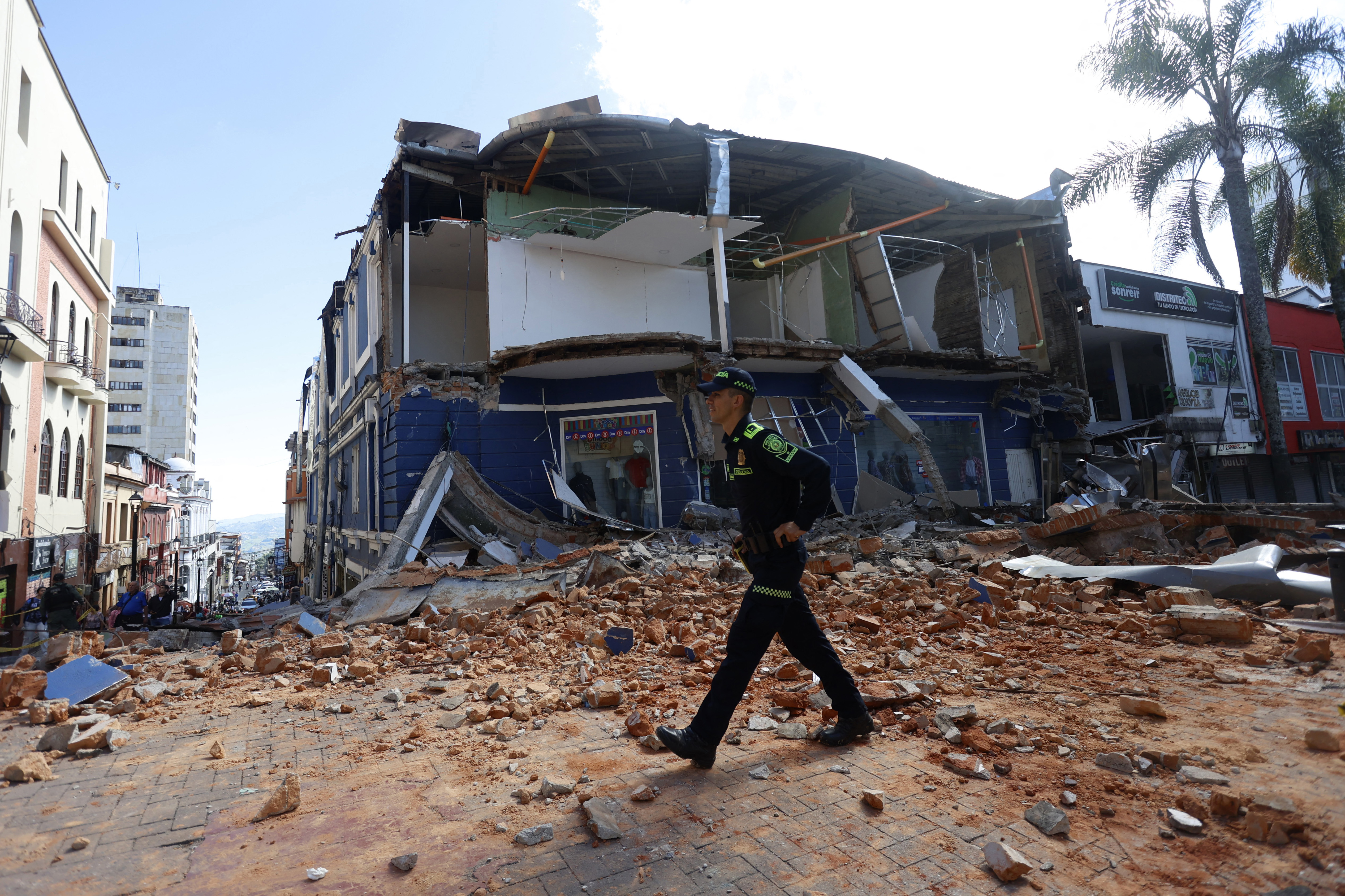 A police officer walks amid debris of a damaged commercial store after the earthquake in Manizales, Colombia, on August 10, 2026. A strong earthquake struck Colombia on August 10 and was strongly felt in major cities such as Bogota and Cali, and even in Quito and Panama, according to the Colombian Geological Service and as confirmed by AFP reporters. (Photo by Jonh Bonilla / AFP)