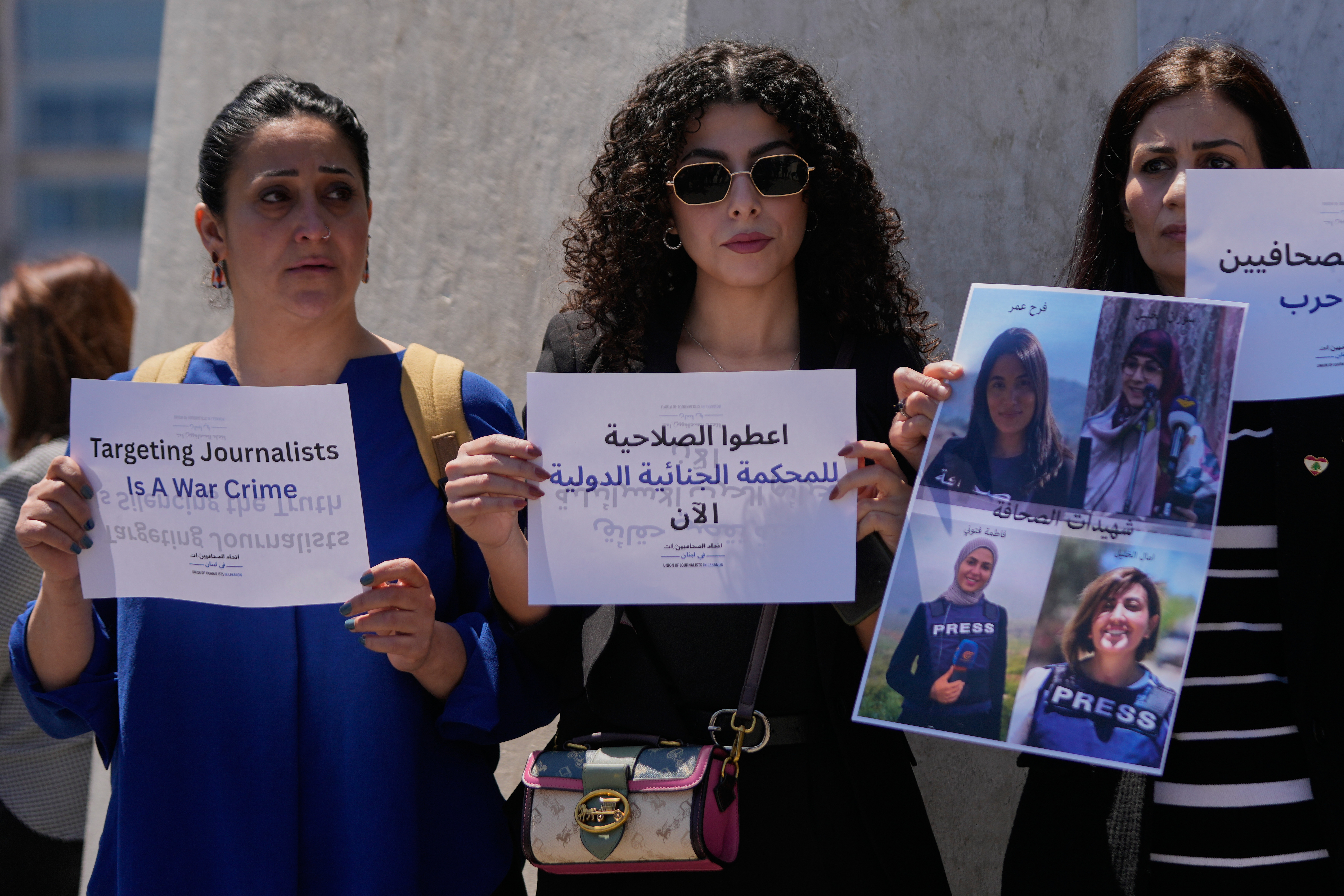 Journalists hold placards and a poster that show portraits of Lebanese journalist Amal Khalil who was killed on Wednesday in an Israeli airstrike along with other journalists, during a sit-in in Beirut, Lebanon, Thursday, April 23, 2026. The Arabic placard centre reads:"Give the authority for the International Criminal Court now." (AP Photo/Hussein Malla)
