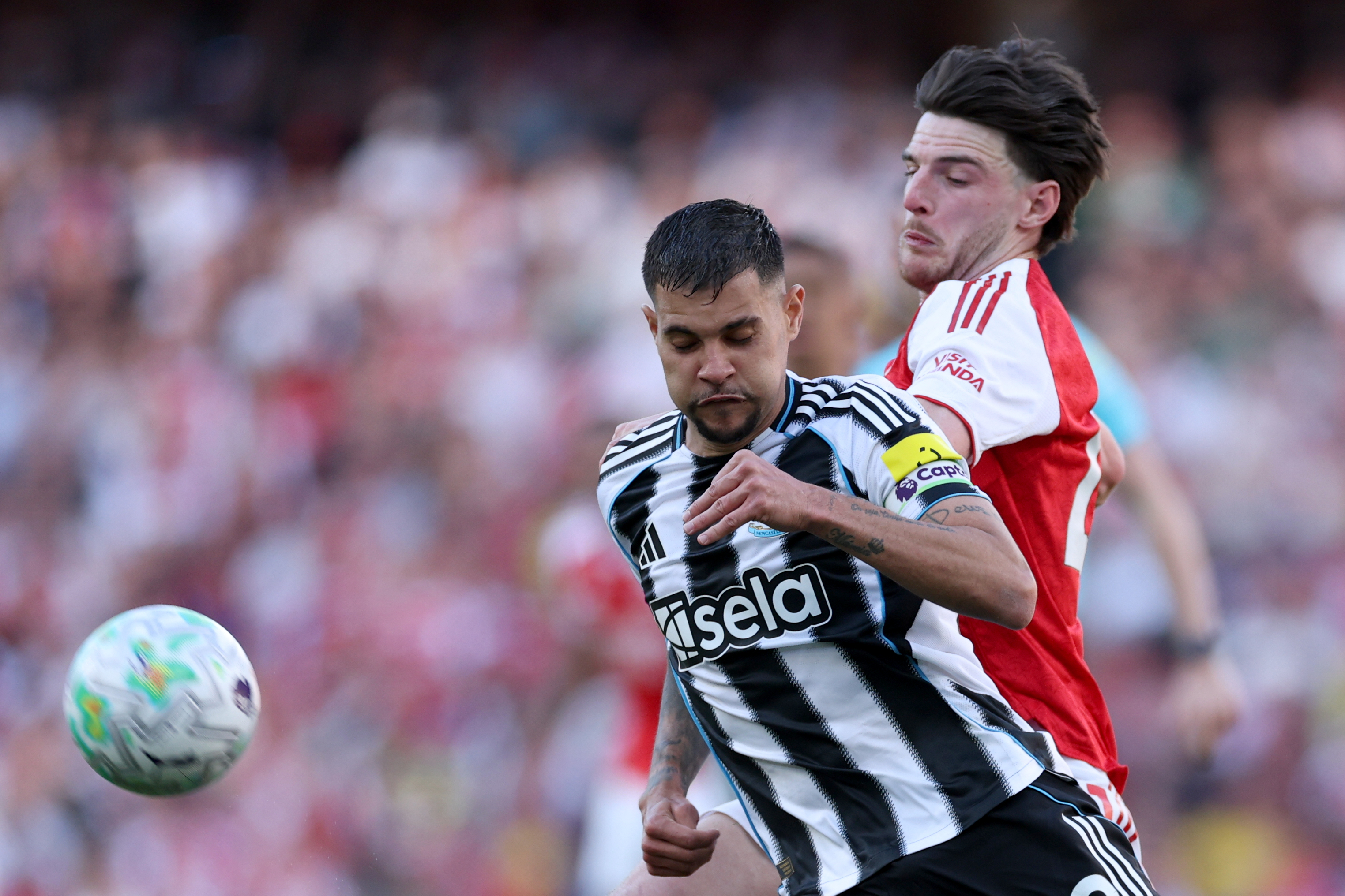 Newcastle's Bruno Guimaraes, front, and Arsenal's Declan Rice challenge for the ball during a match.