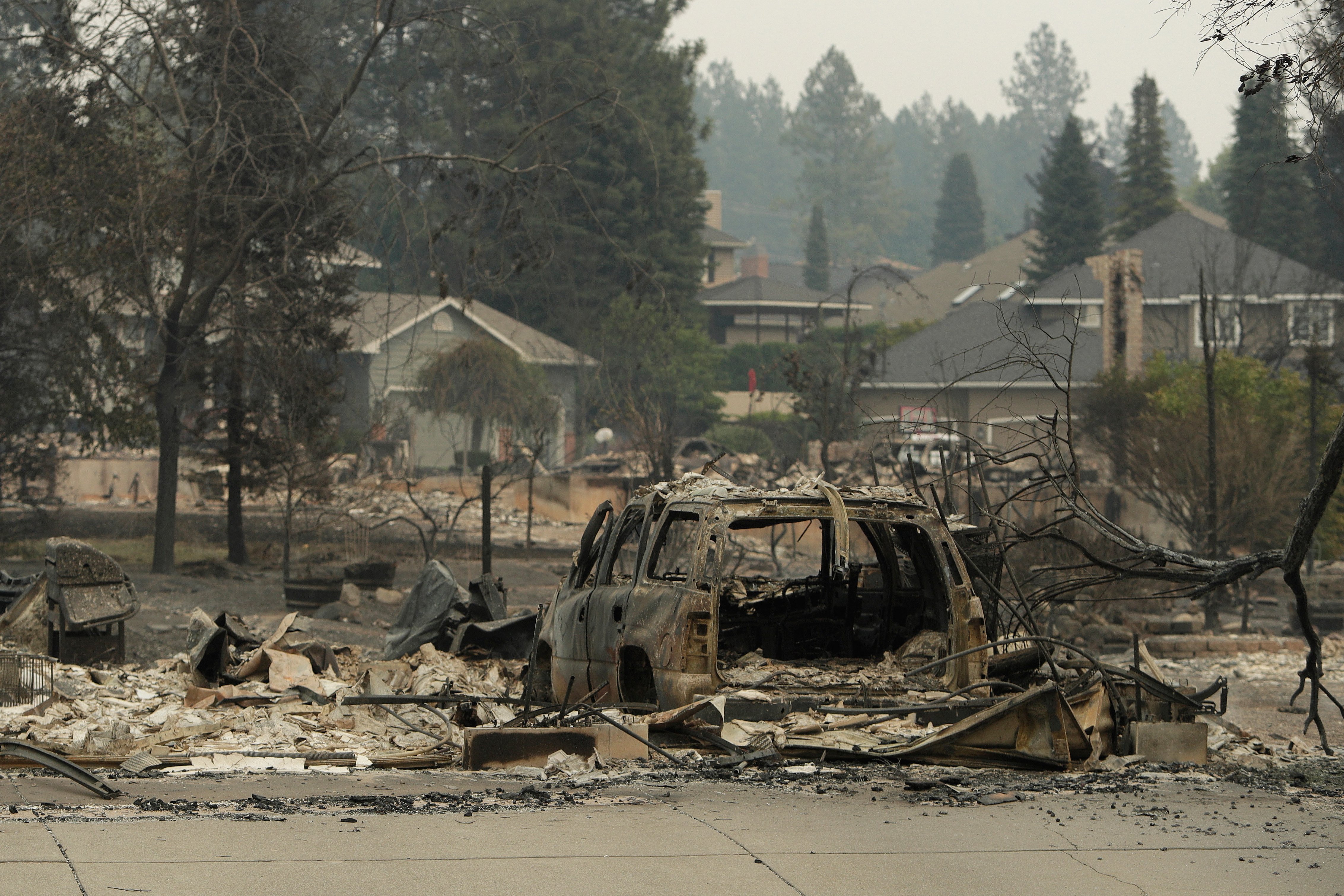 A vehicle and structure are burned on N. Skyline Dr. due to a wildfire. [Young Kwak/AP Photo]