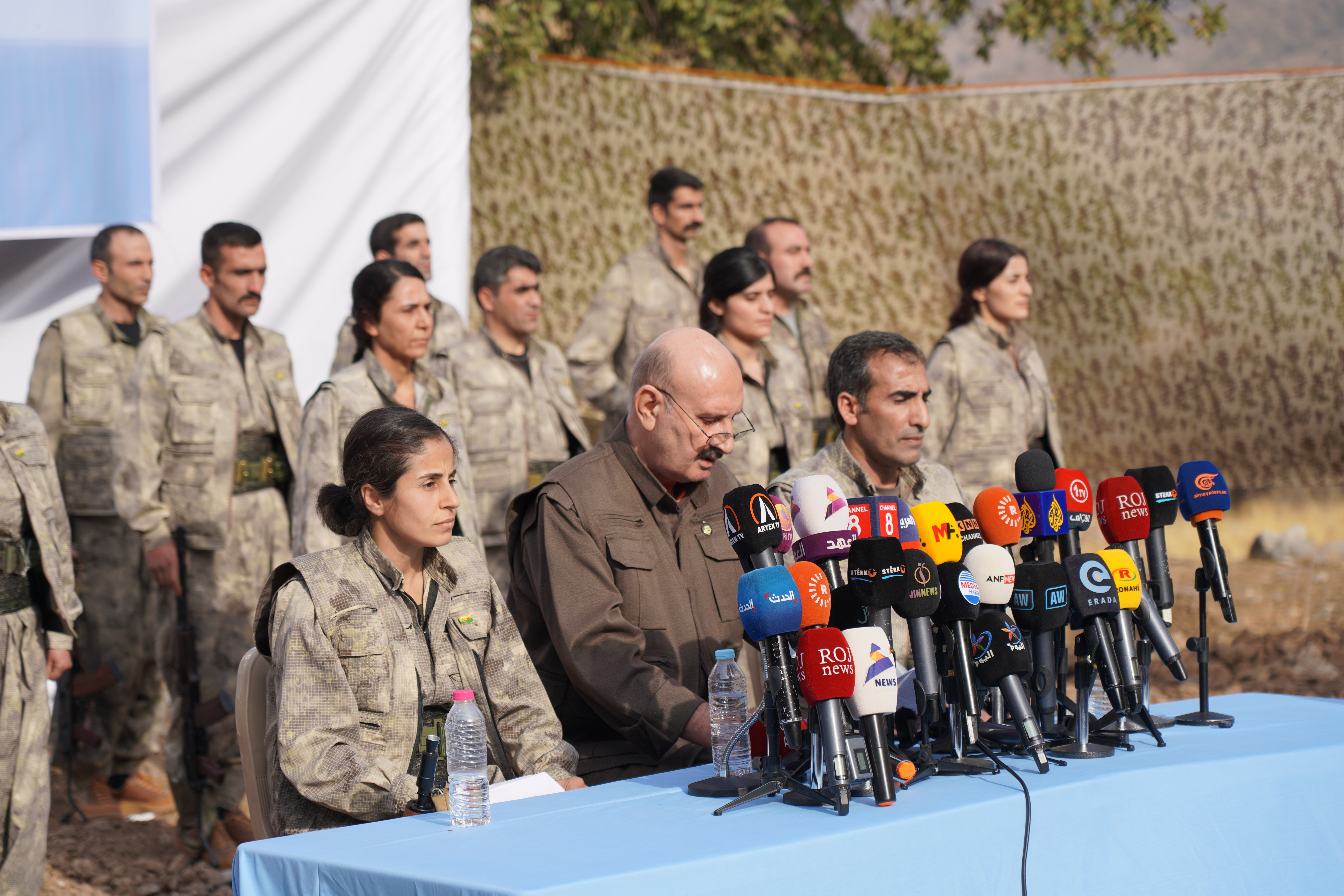 Kurdistan Workers' Party (PKK) fighters stand to attention during a ceremony in the Qandil area of northern Iraq on October 26, 2025.