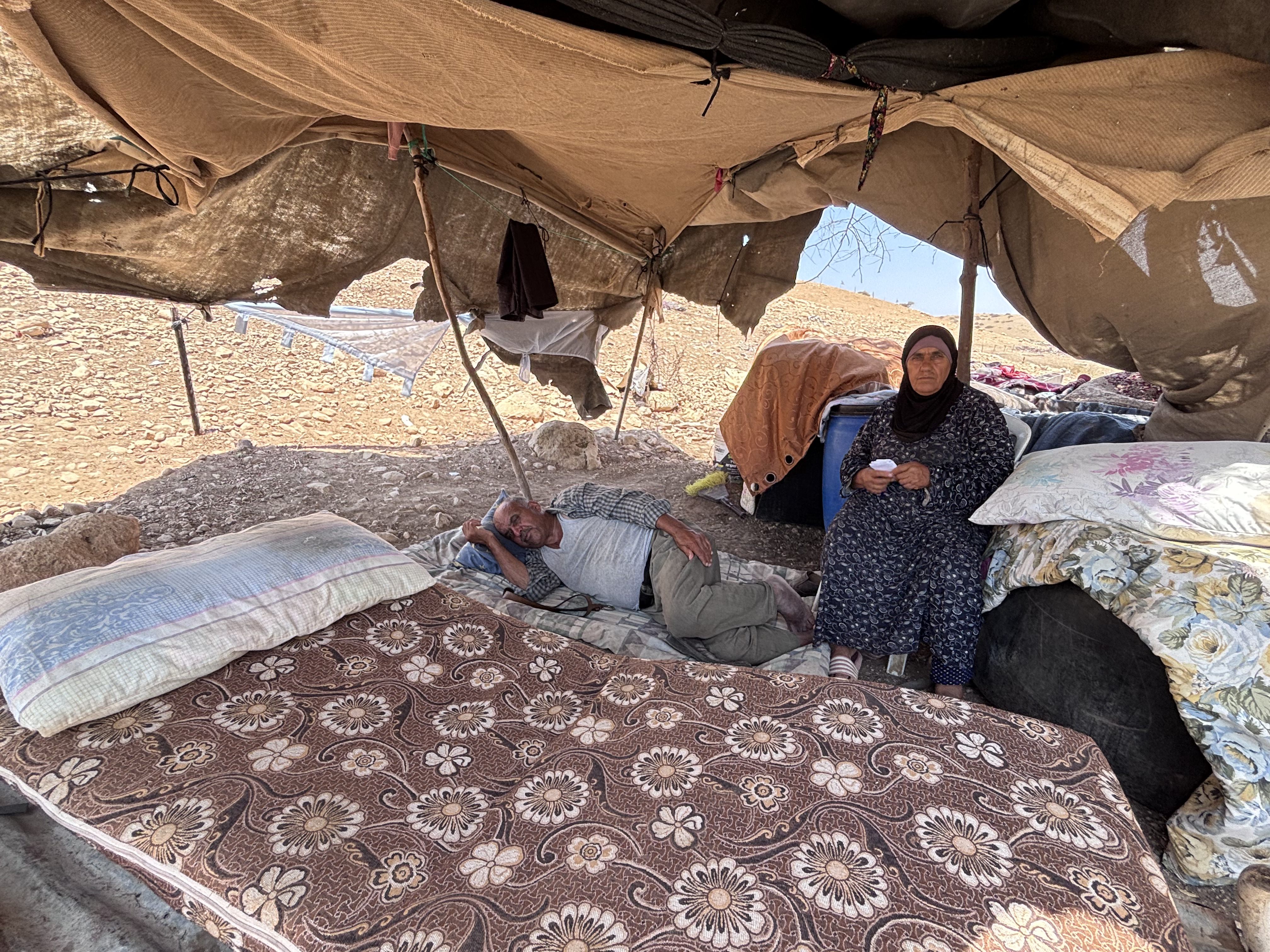Adel and Kheirieh Daraghmeh lying in temporary shelter midday next to the ruins of their home in Ein el-Hilweh [Al Jazeera]