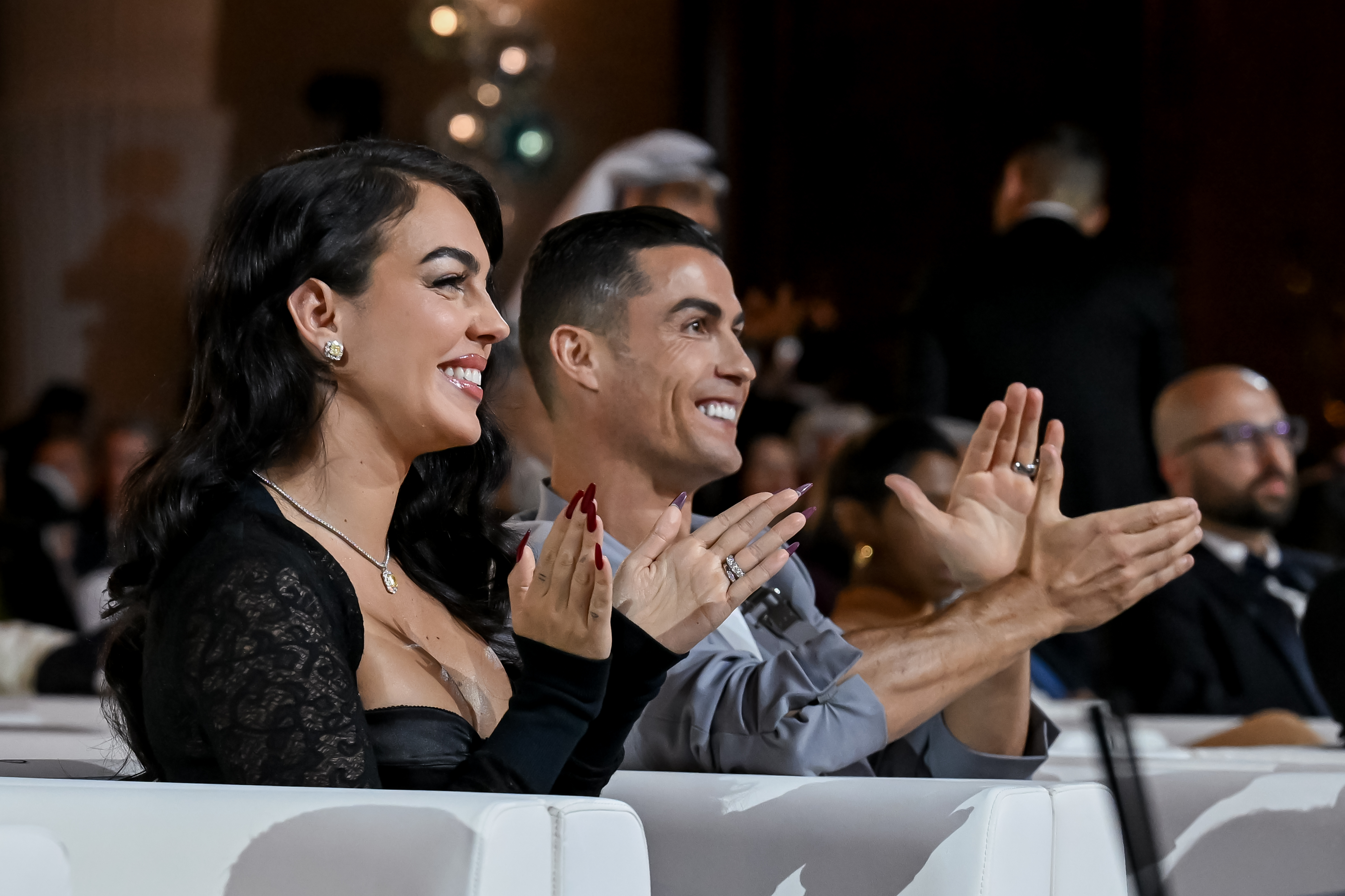 A man and a woman clap their hands at an event