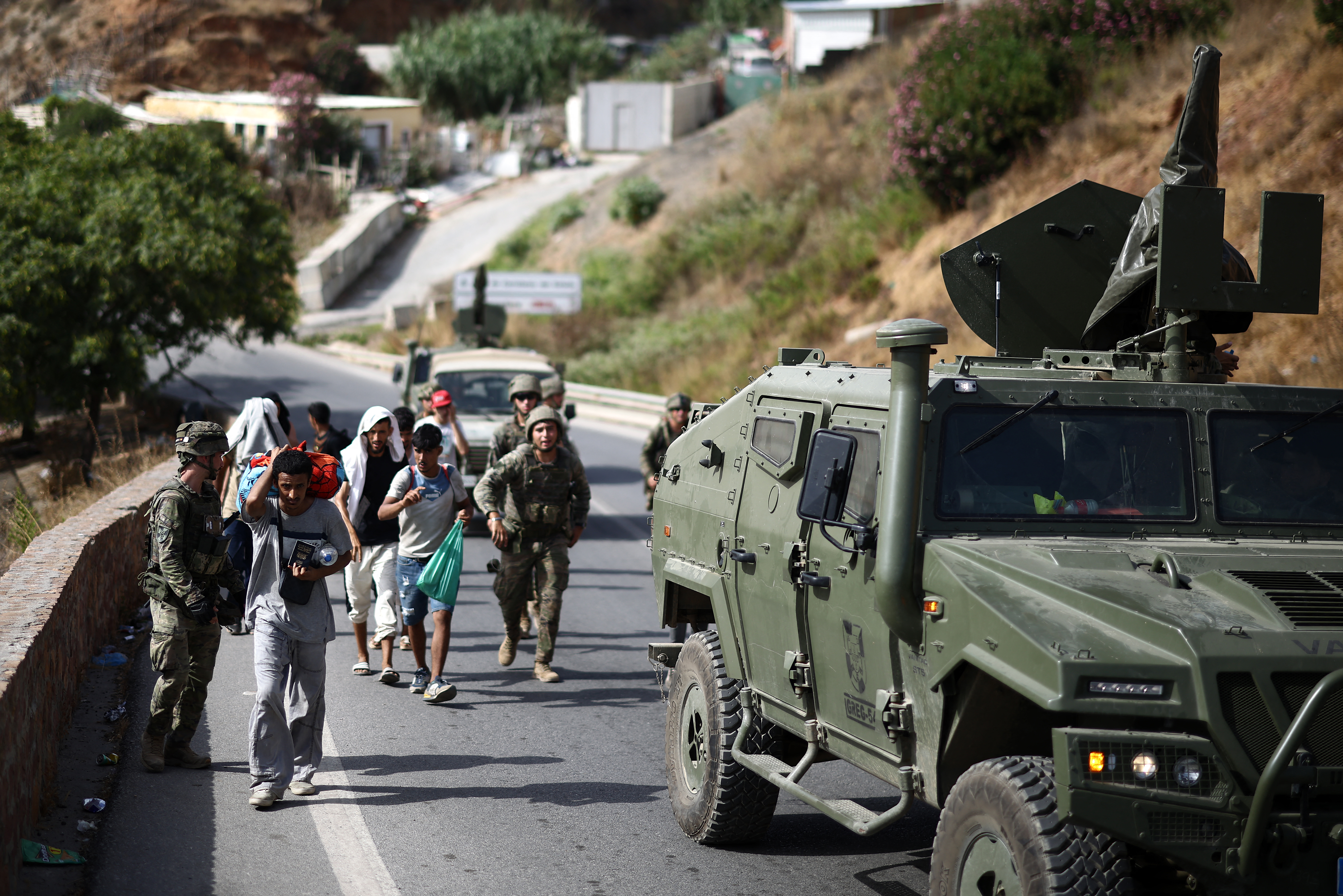 Spanish soldiers escort migrants to the border in the Spanish North African enclave of Ceuta on August 1, 2026.