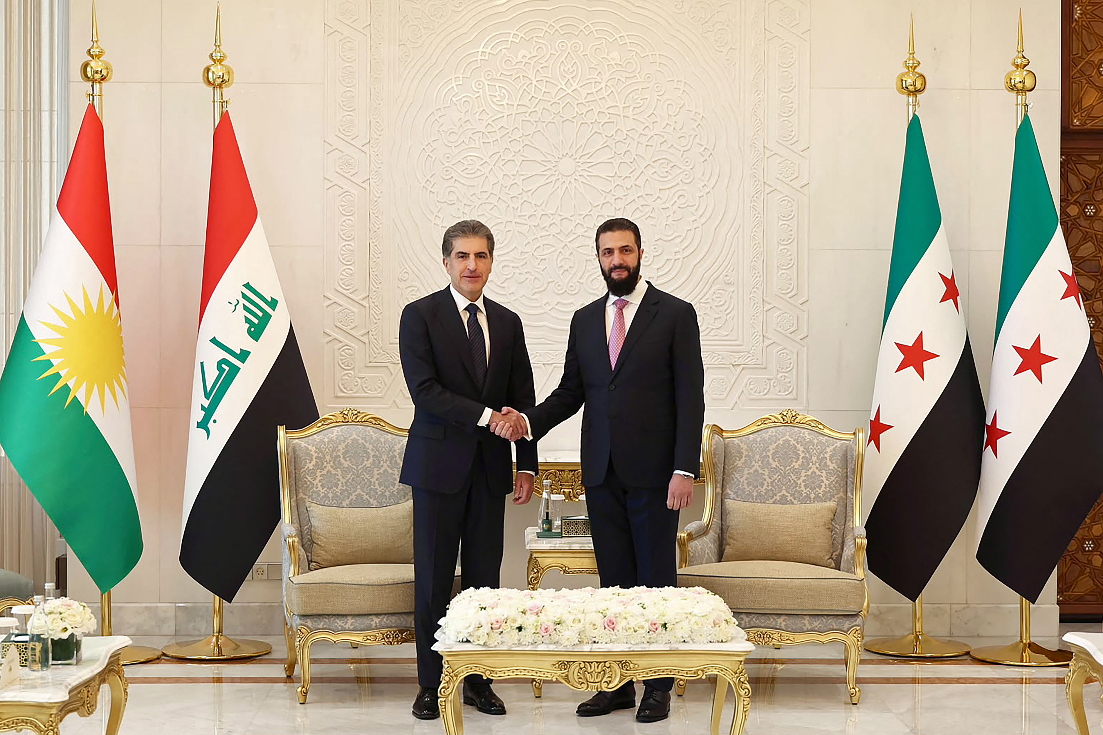 This handout photograph taken and released by the Iraq’s Kurdistan Region Presidency on August 3, 2026 shows Syria's President Ahmad al-Sharaa (R) shaking hands with the President of Iraq's Kurdish region Nechirvan Barzani before their meeting in Damascus. (Photo by Iraq’s Kurdistan Region Presidency / AFP) / RESTRICTED TO EDITORIAL USE - MANDATORY CREDIT "AFP PHOTO / IRAQ’S KURDISTAN REGION PRESIDENCY" - HANDOUT - NO MARKETING NO ADVERTISING CAMPAIGNS - DISTRIBUTED AS A SERVICE TO CLIENTS