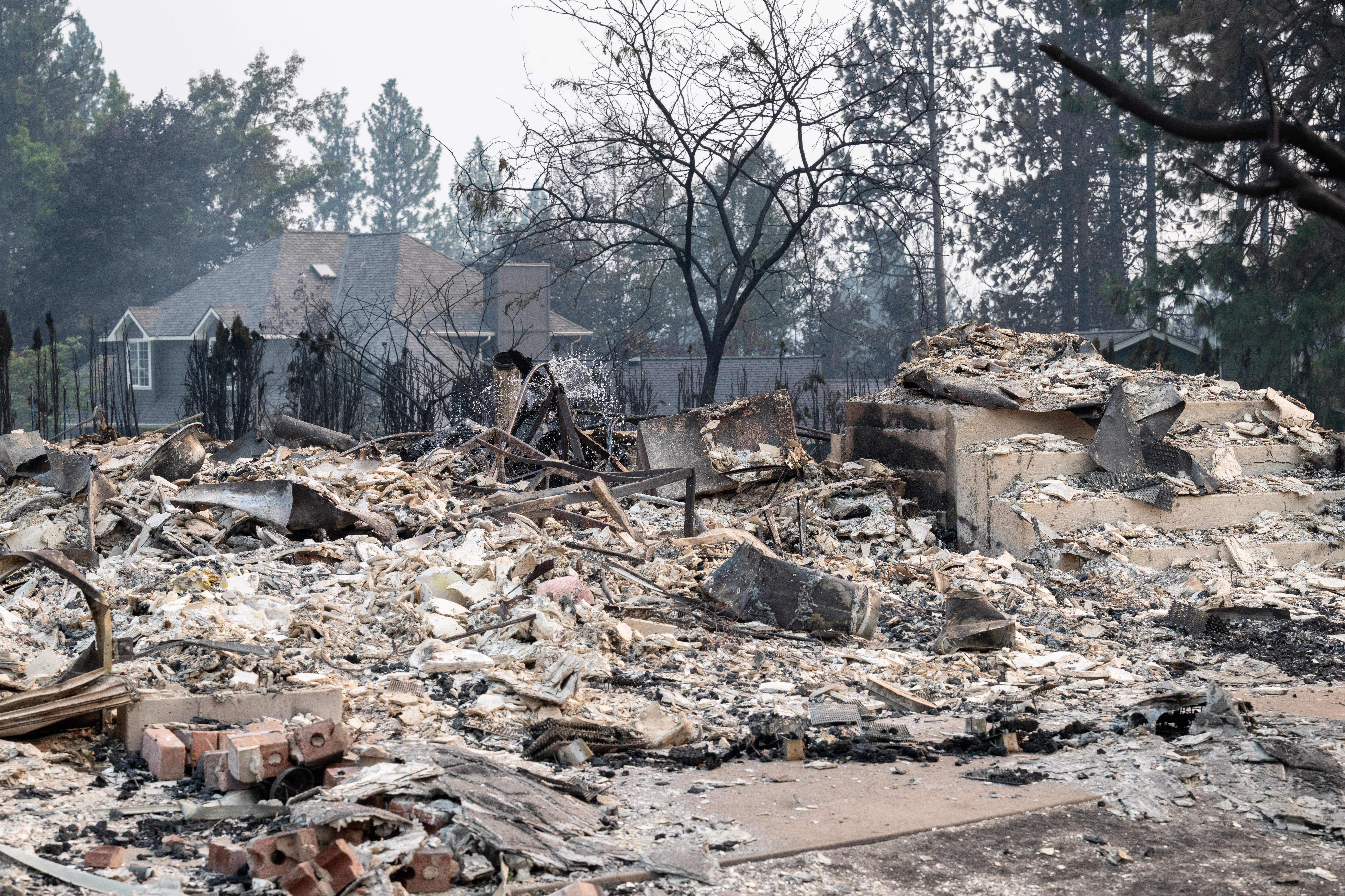 The rubble of a burned out home smolders in the Balboa neighbourhood of Spokane, Washington, US