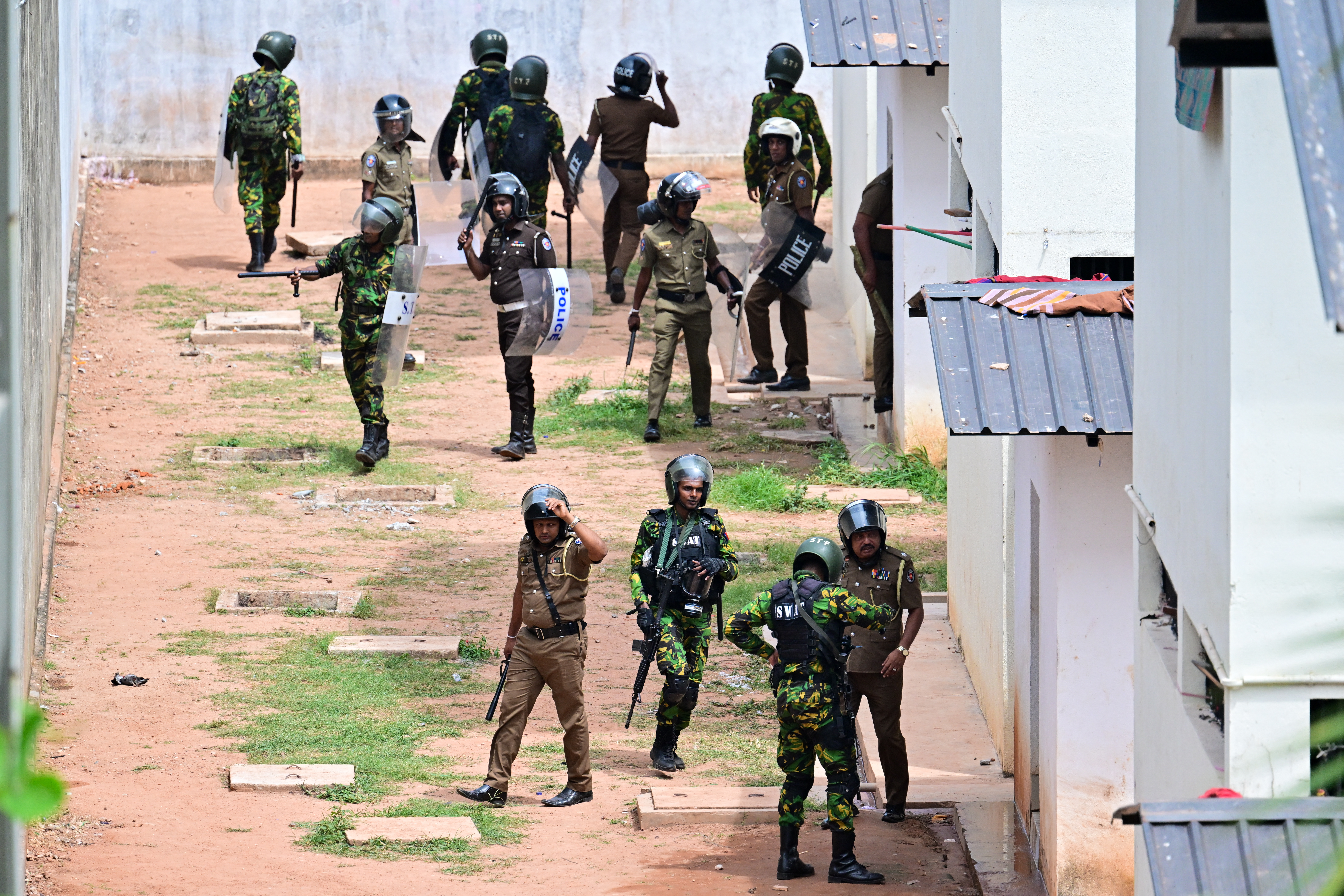Sri Lanka Special Task Force (STF) and police personnel patrol during a riot at the Pallansena open prison on August 7, 2026 amid a stand-off between inmates and their guards.
