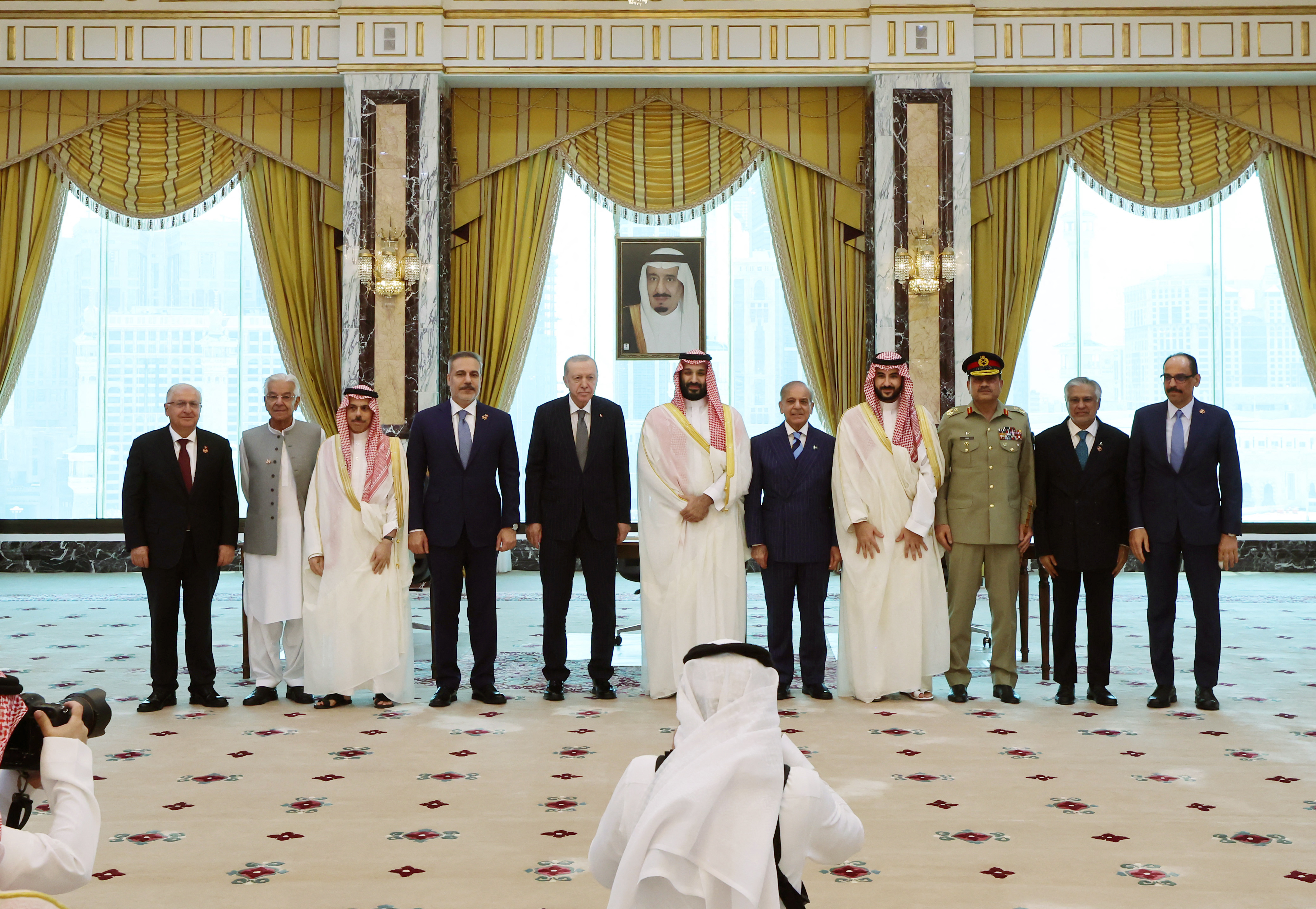 This handout photograph taken and released by Turkish Presidency Press Office on August 7, 2026, shows Minister of Foreign Affairs of Saudi Arabia Prince Faisal bin Farhan al-Saud (3rd L), Turkish Foreign Minister Hakan Fidan (4th L), Turkish President Recep Tayyip Erdogan (5th L), Saudi Crown Prince Mohammed bin Salman (C), Pakistani Prime Minister Shehbaz Sharif (5th R), Saudi Defense Minister Prince Khalid bin Salman al-Saud (4th R), and their delegations as they pose after signing a trilateral joint defense agreement in Mecca, Saudi Arabia.