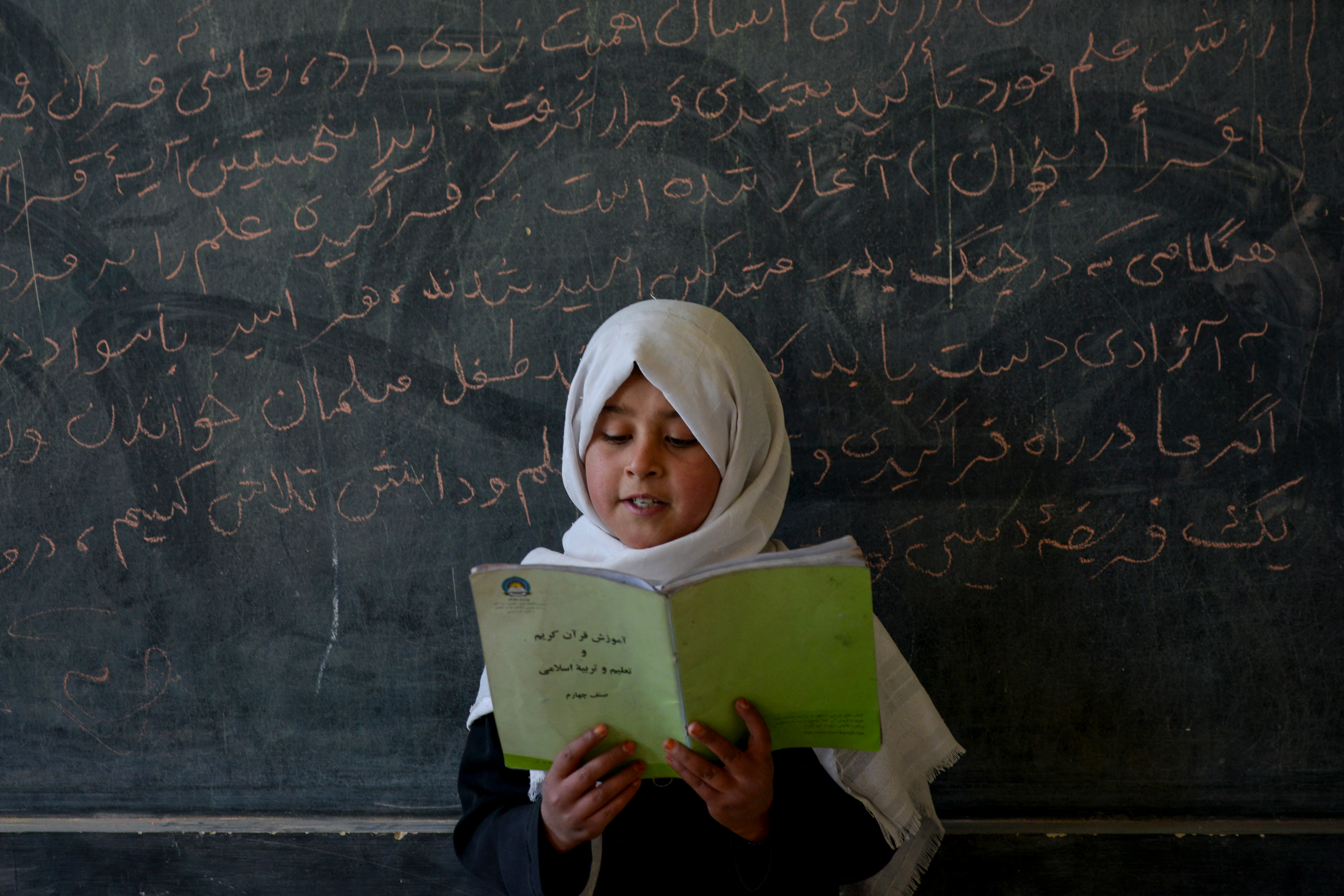 (FILES) An Afghan girl reads a book in a classroom at a primary school on the outskirts of Fayzabad district in of Afghanistan's Badakhshan province on November 18, 2025.