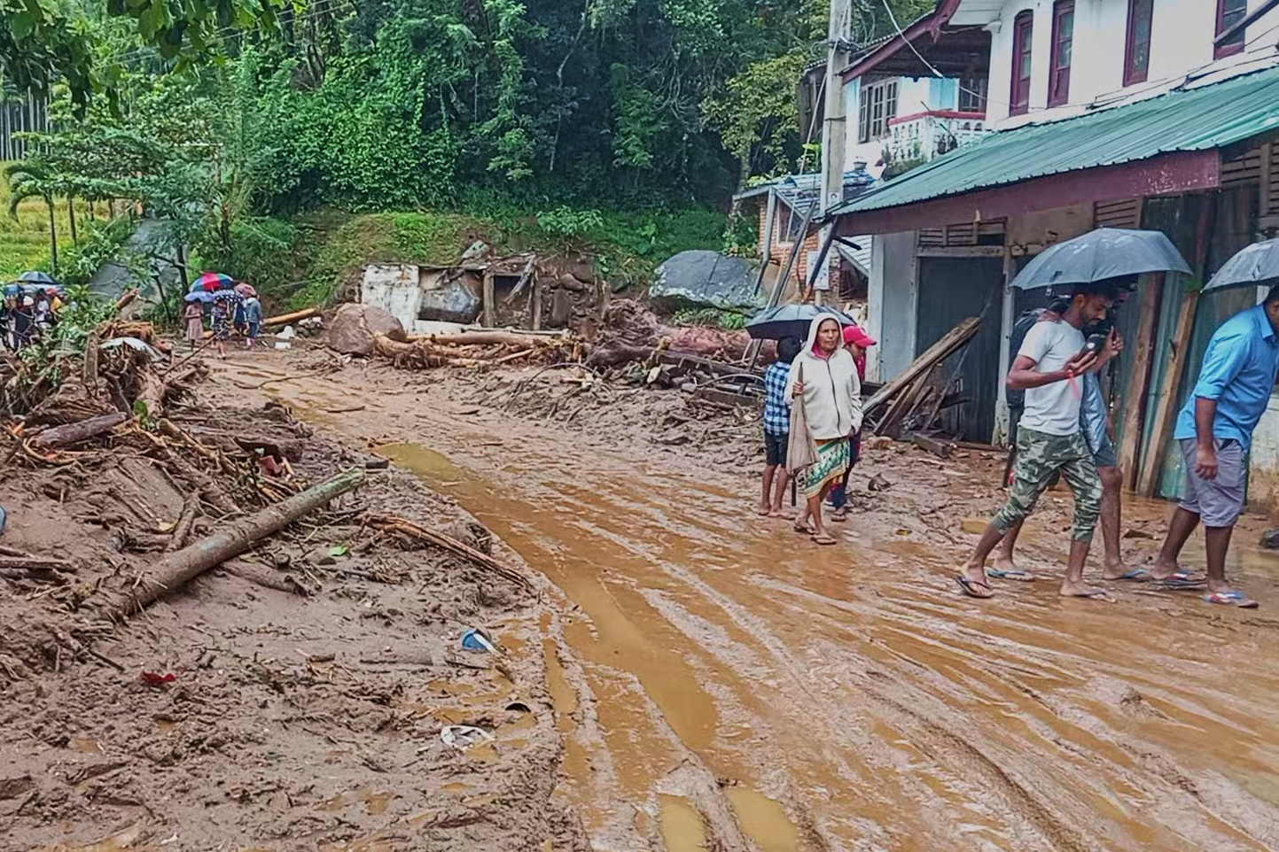 People walk across a mud covered road following heavy rain in Nawalapitiya, Sri Lanka, Tuesday, Aug. 4, 2026 [Photo: AP]