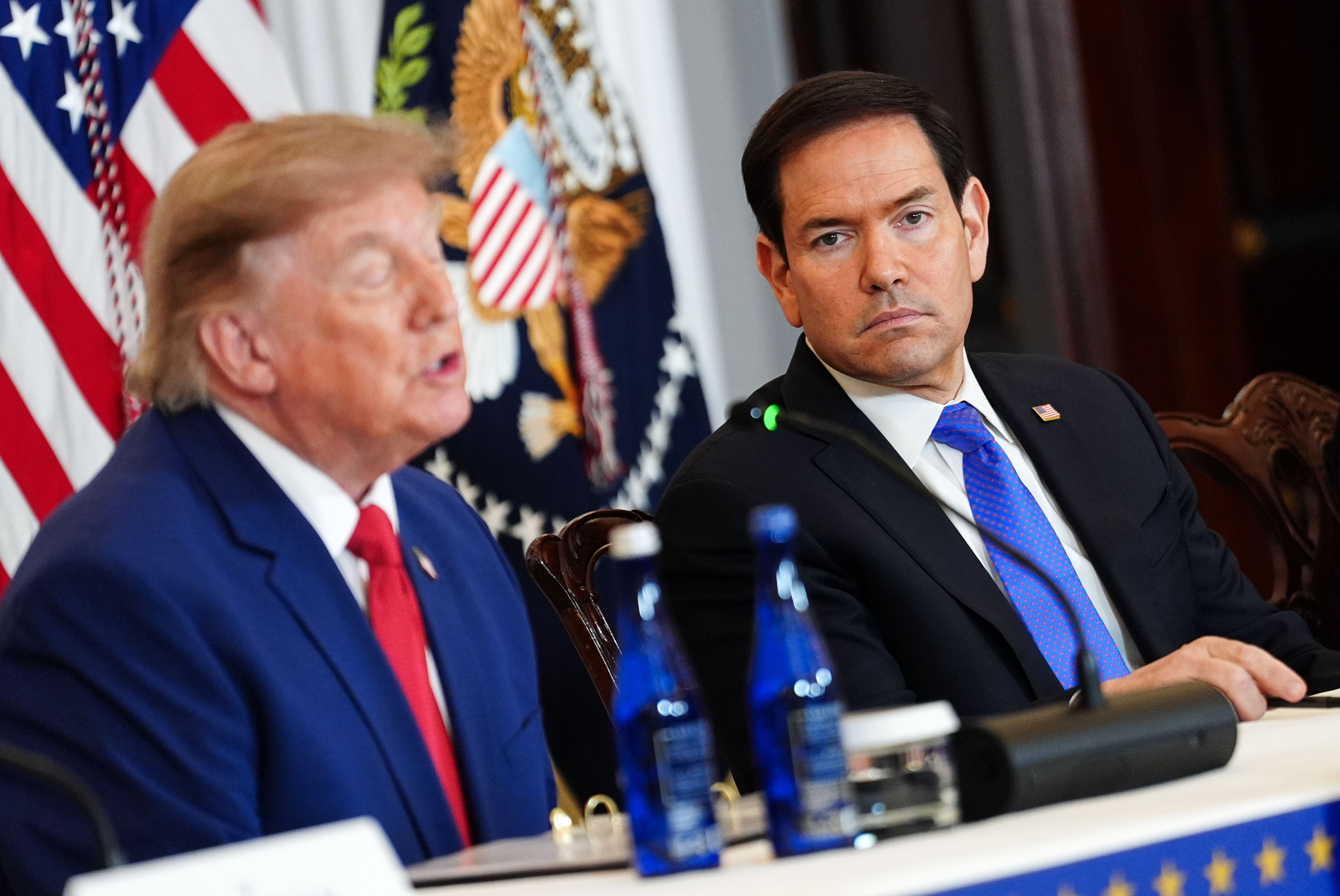 Secretary of State Marco Rubio listens as President Donald Trump speaks during a roundtable on the American mining industry, Friday, Aug. 7, 2026, at the State Department in Washington. (AP Photo/Julia Demaree Nikhinson)