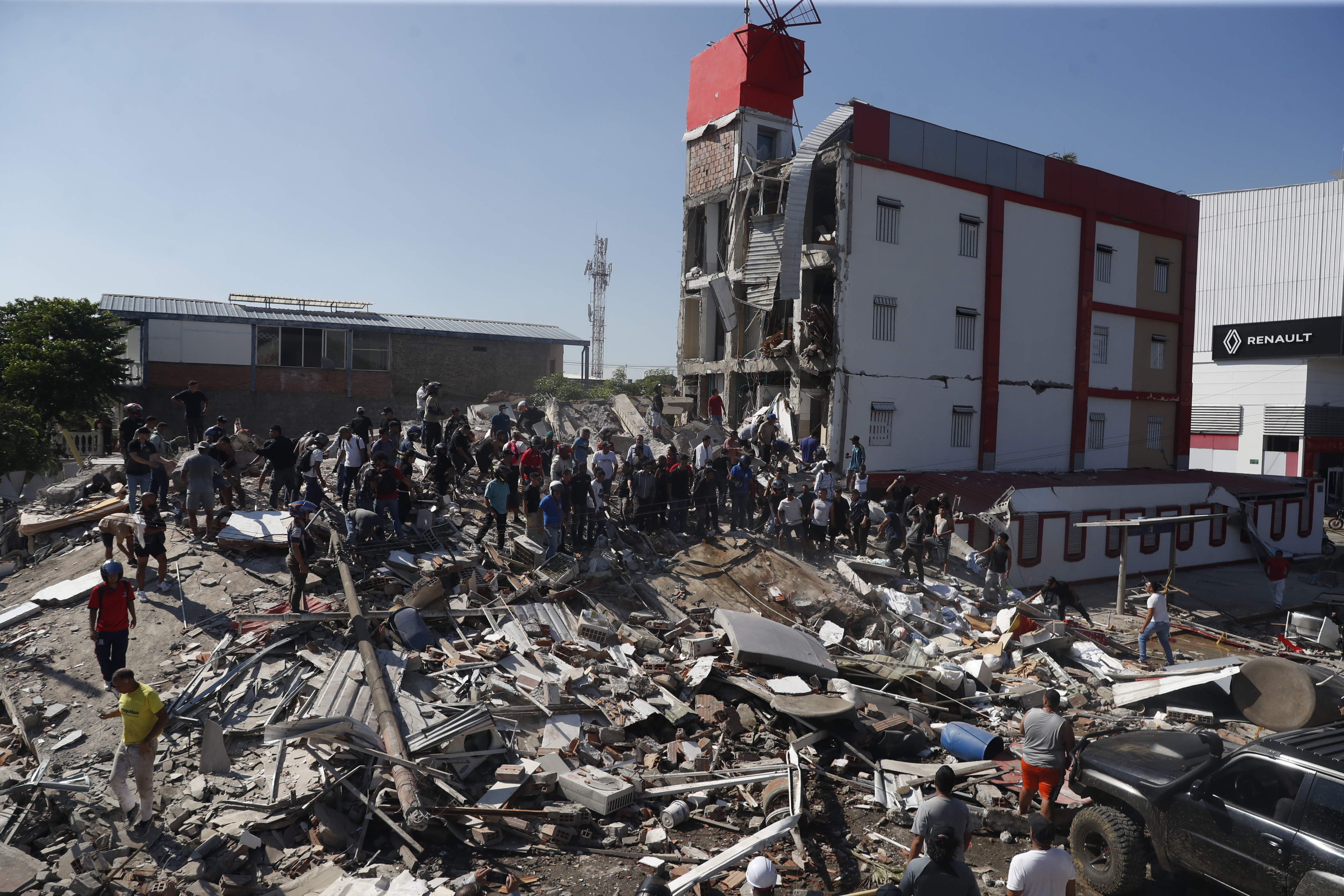epa13159752 People walk through the rubble of a collapsed building after an earthquake in Cali, Colombia, 10 August 2026. At least 20 buildings sustained severe damage as a result of the 7.4-magnitude earthquake that shook most of the country, with its epicenter in the Pacific region. EPA/ERNESTO GUZMAN JR