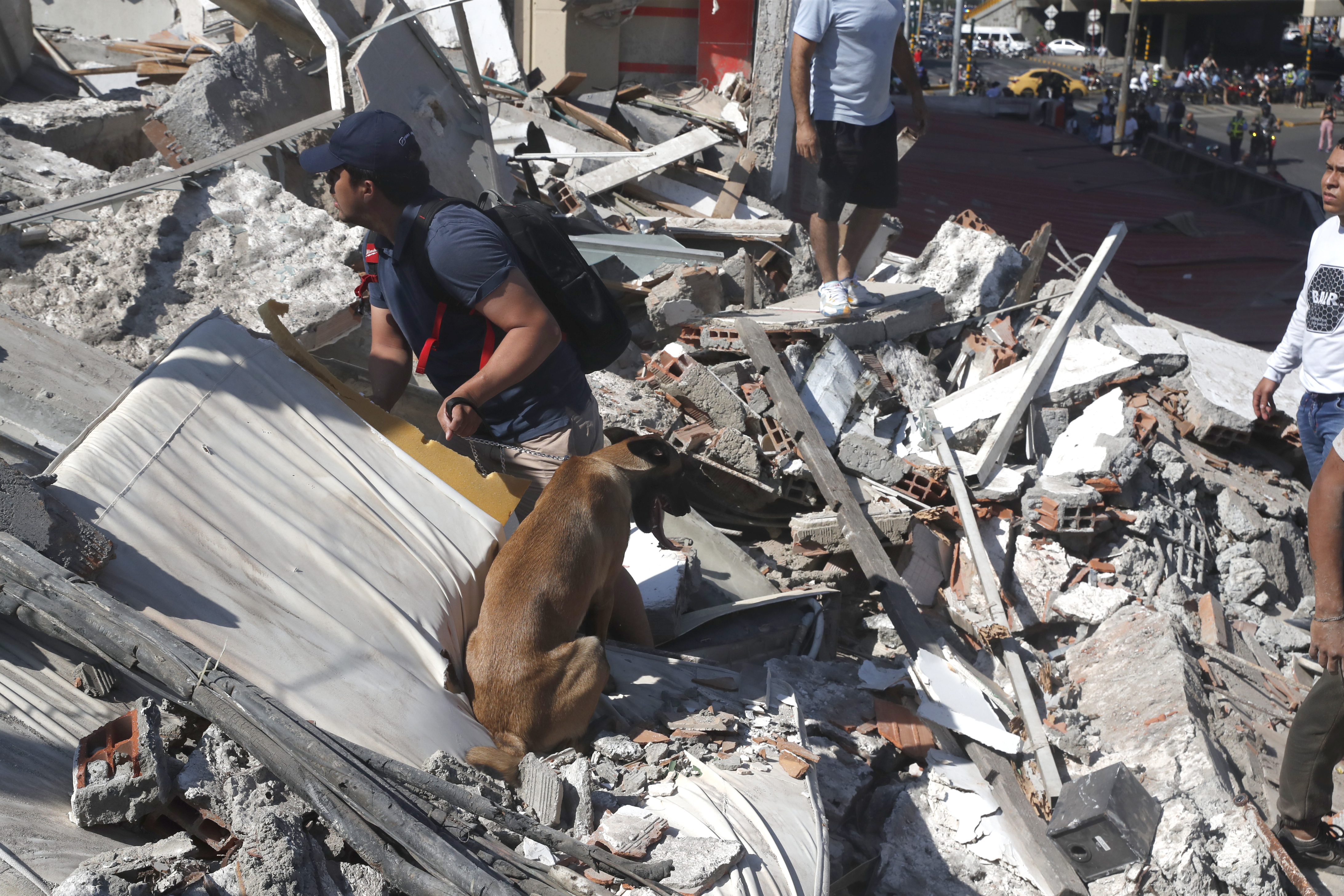 epa13159753 People walk through the rubble of a collapsed building after an earthquake in Cali, Colombia, 10 August 2026. At least 20 buildings sustained severe damage as a result of the 7.4-magnitude earthquake that shook most of the country, with its epicenter in the Pacific region. EPA/ERNESTO GUZMAN JR