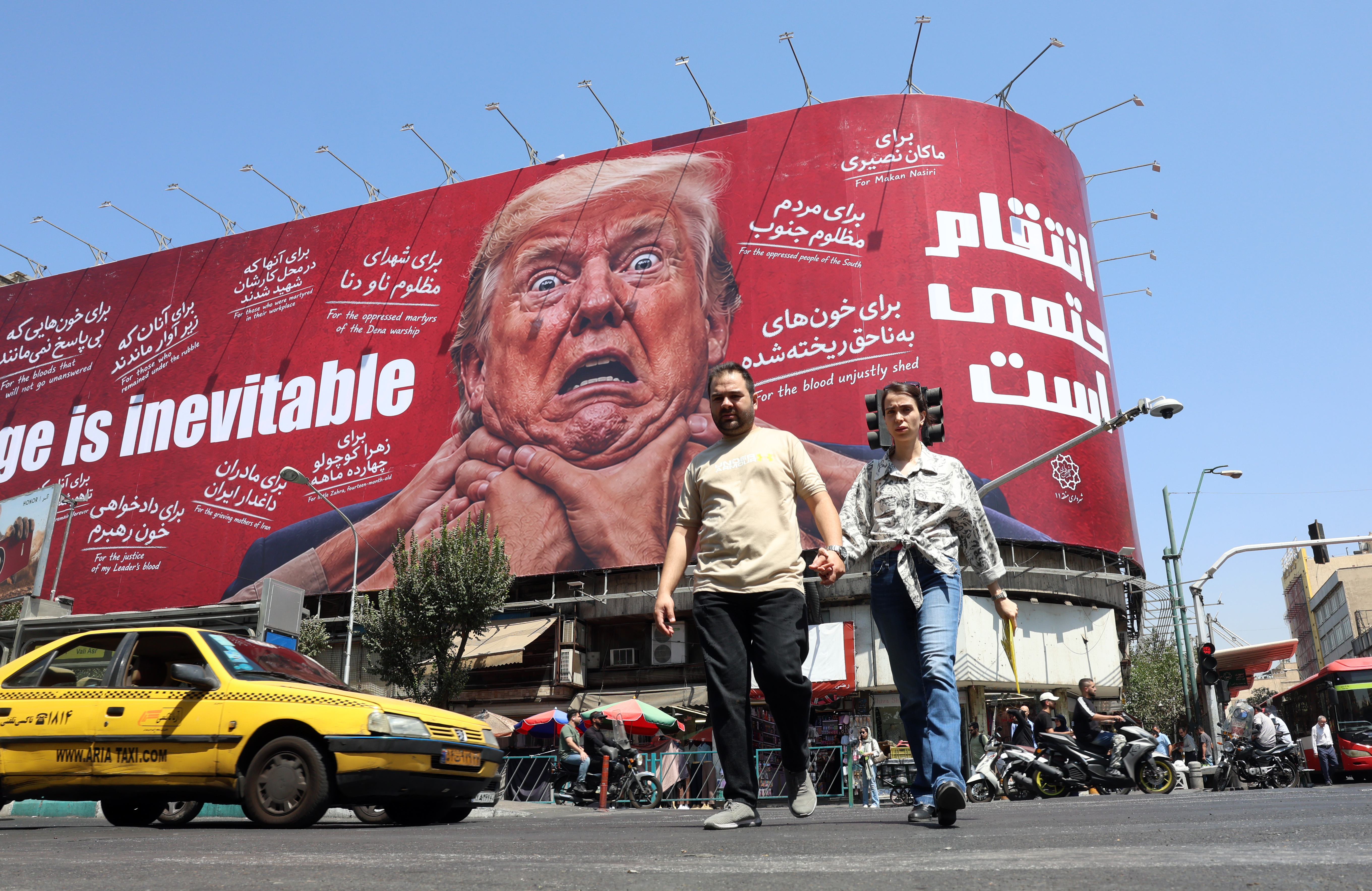 Iranians walk near an anti-Trump billboard in Tehran, Iran, August 19, 2026