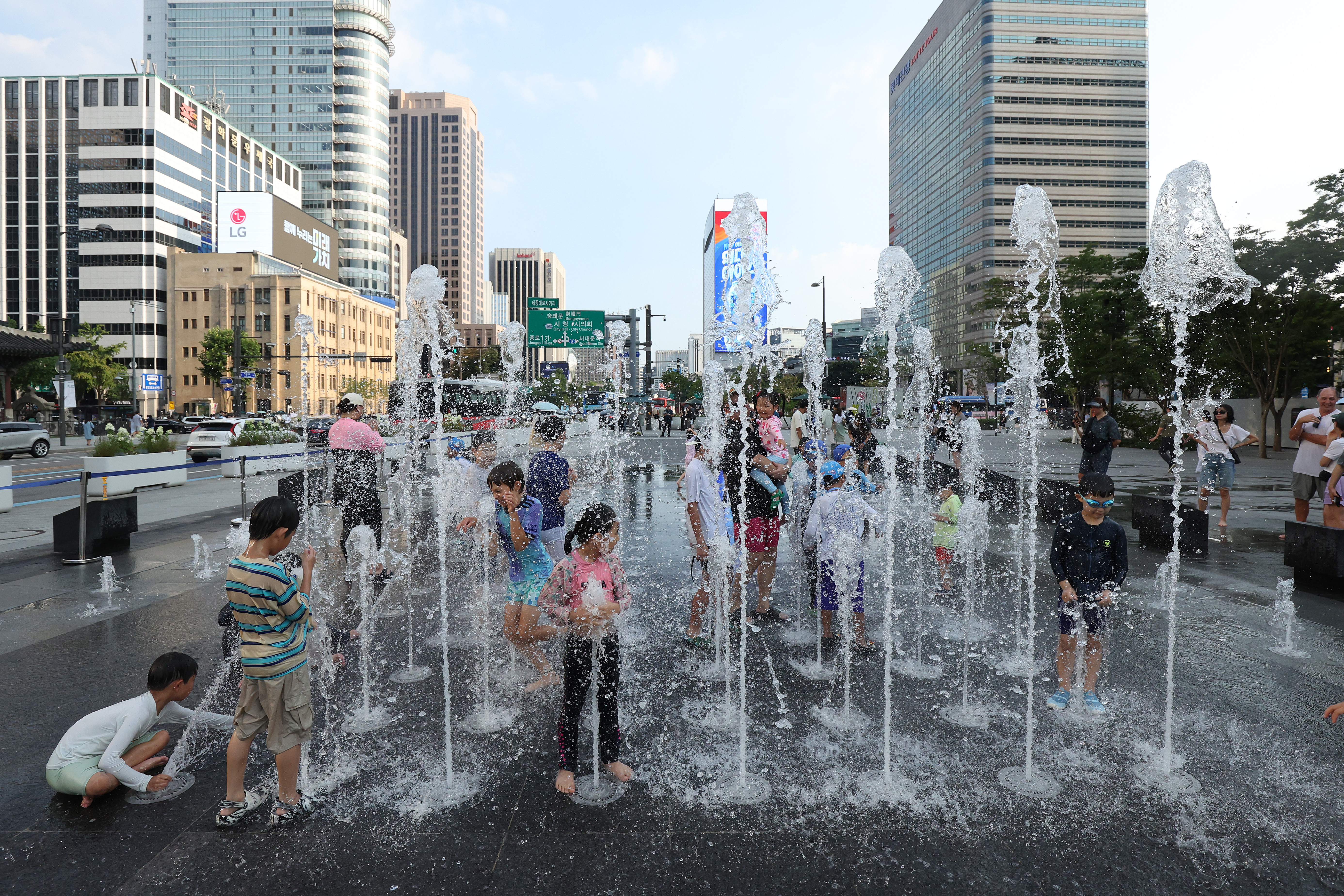 Children play in the water fountains during a heatwave in Seoul, South Korea