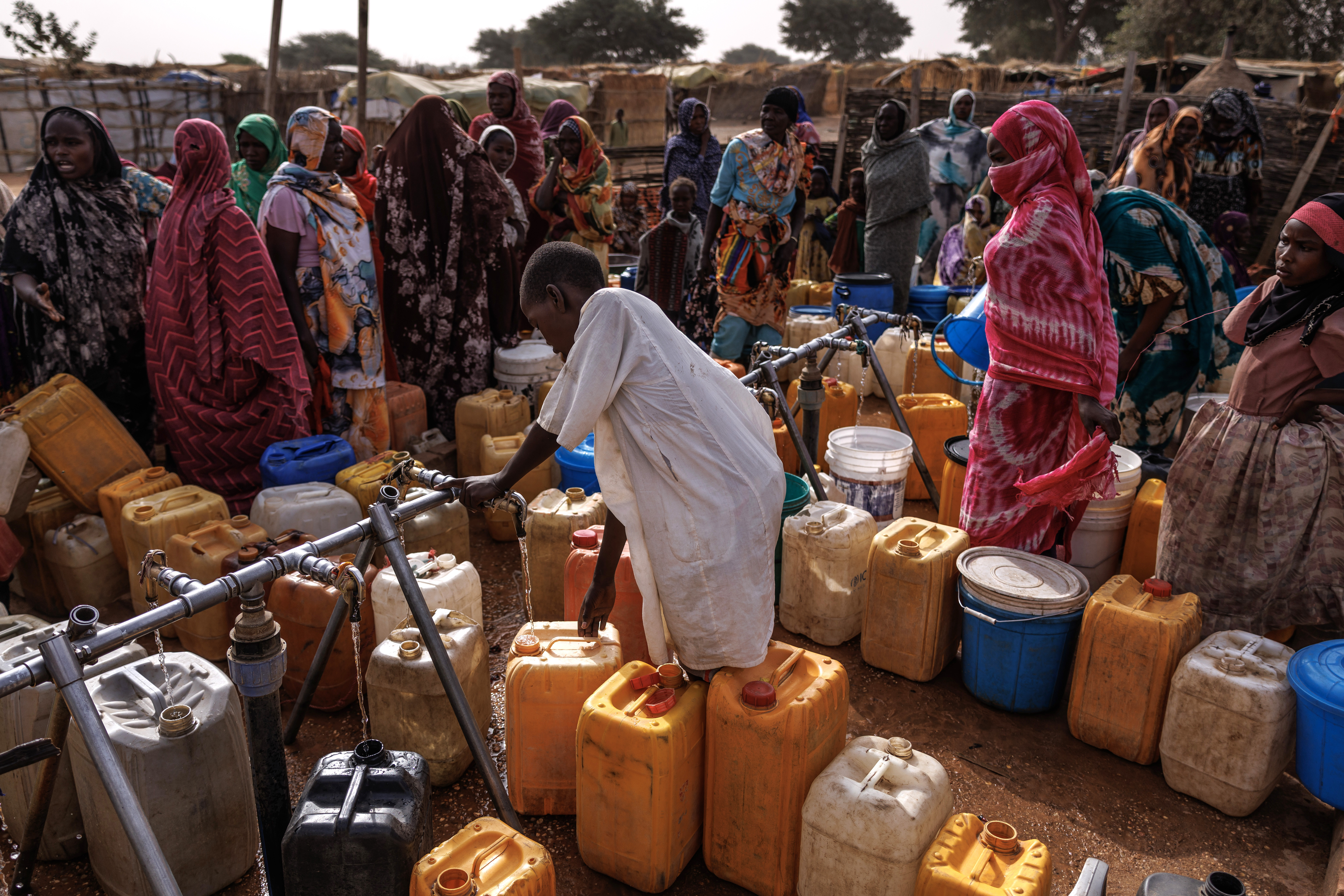 ADRE, CHAD - FEBRUARY 19: A young Sudanese boy collects water on February 19, 2026 in Adre, Chad. In April 2023 civil war erupted between the Sudanese Armed Forces (SAF) and the armed militia group Rapid Support Forces (RSF). The ongoing conflict has so far displaced around 14 million people across the region, triggering a widespread humanitarian crisis, as neighboring countries like Chad struggle to absorb refugees, while coping with populations already suffering high poverty rates and food insecurity. Chad has become Africa's largest host of refugees per capita, hosting a total 1.4 million refugees - more than 900,000 of which fled the conflict in Sudan. The most recent wave of arrivals from Sudan follows the RSF's offensive to capture the north Darfur city of El Fasher, where 6,000 people were reportedly killed by the RSF in the space of three days in October. A recent UN report has accused the RSF of atrocities that amount to war crimes and possible crimes against humanity. As many as 400,000 people have reportedly been killed since the conflict began. (Photo by Dan Kitwood/Getty Images)