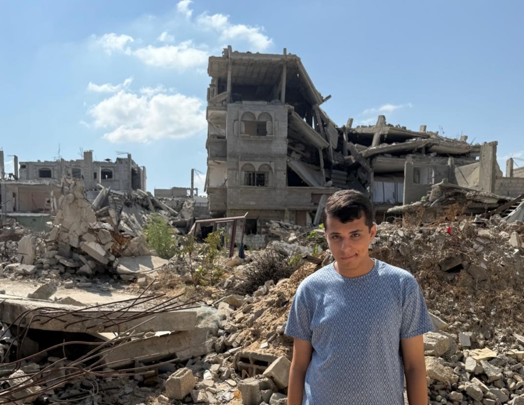 Ahmed stands amidst the rubble of his room, which was destroyed by Israel