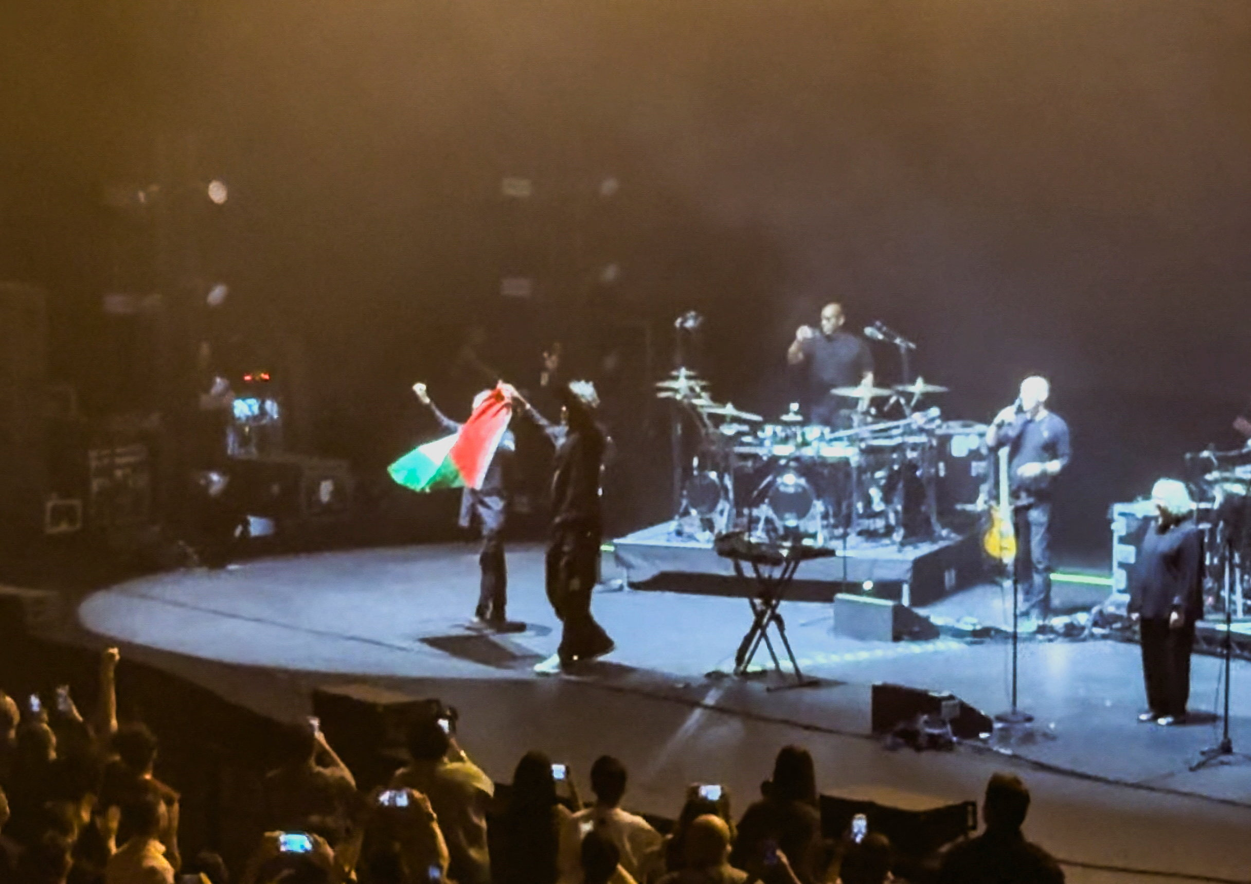 Robert Del Naja and Grant Marshall from Massive Attack stand with a Palestinian flag onstage at the end of their performance in Singapore, July 29, 2026