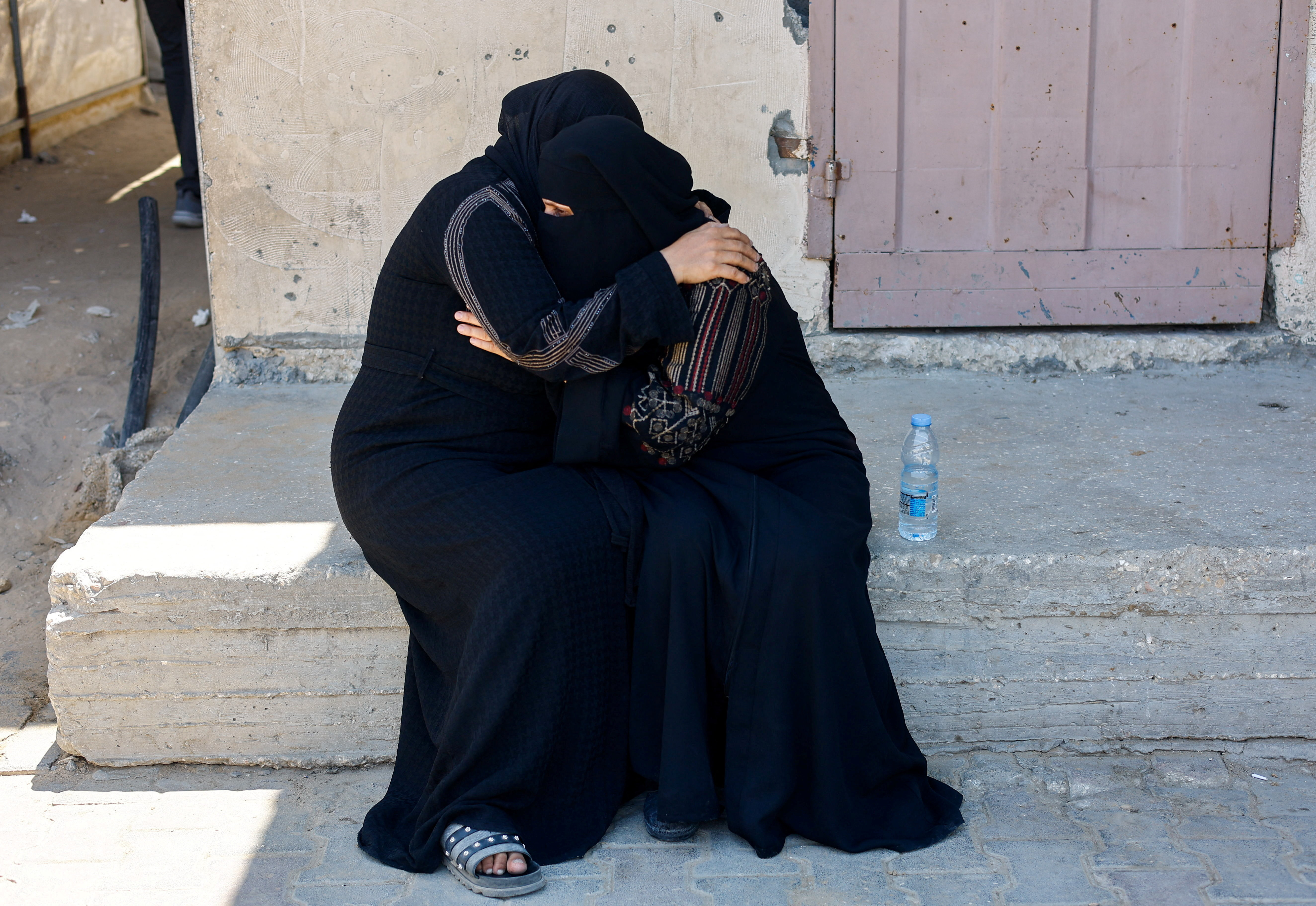 Mourners comfort each other, as they attend the funeral of a Palestinian killed in an Israeli strike in Gaza