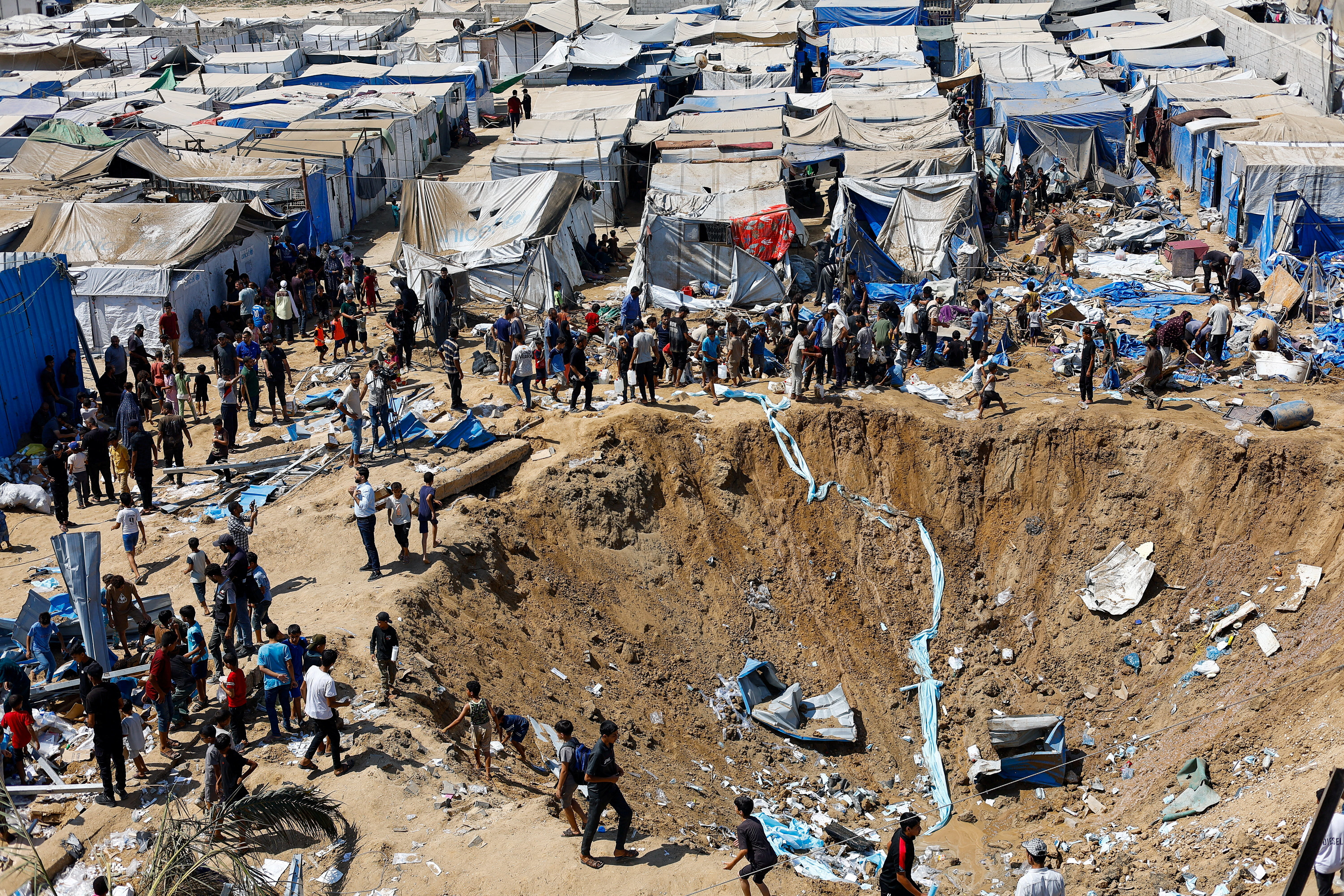 Palestinians inspect the site of an overnight Israeli strike on a medicine warehouse, according to medics, next to tents sheltering displaced Palestinians, in Deir al-Balah, in the central Gaza Strip, August 1, 2026, residents had been pre-warned by the Israeli military to evacuate. REUTERS/Mahmoud Issa REFILE - ADDS INFORMATION