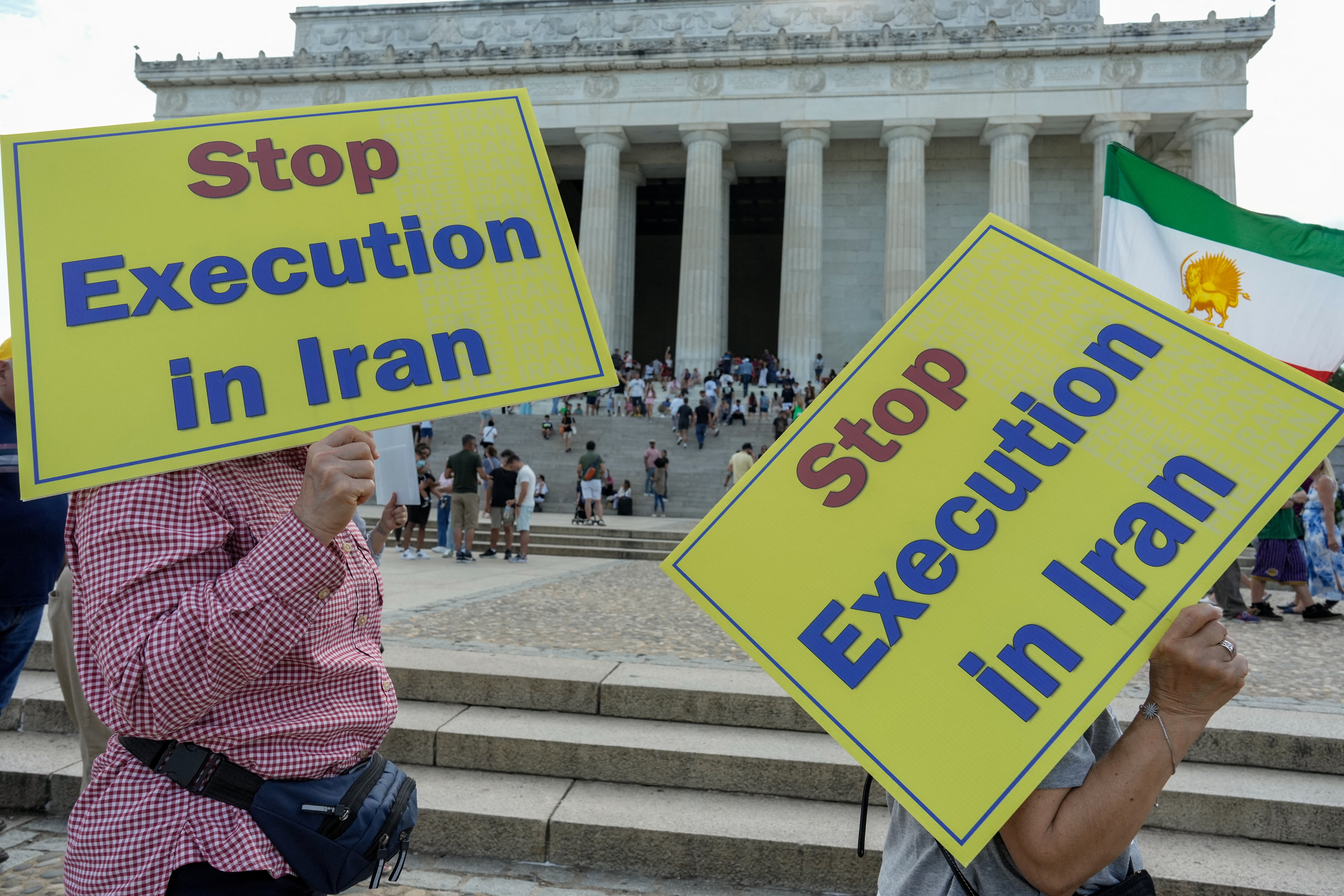 People hold banners reading "Stop execution in Iran".